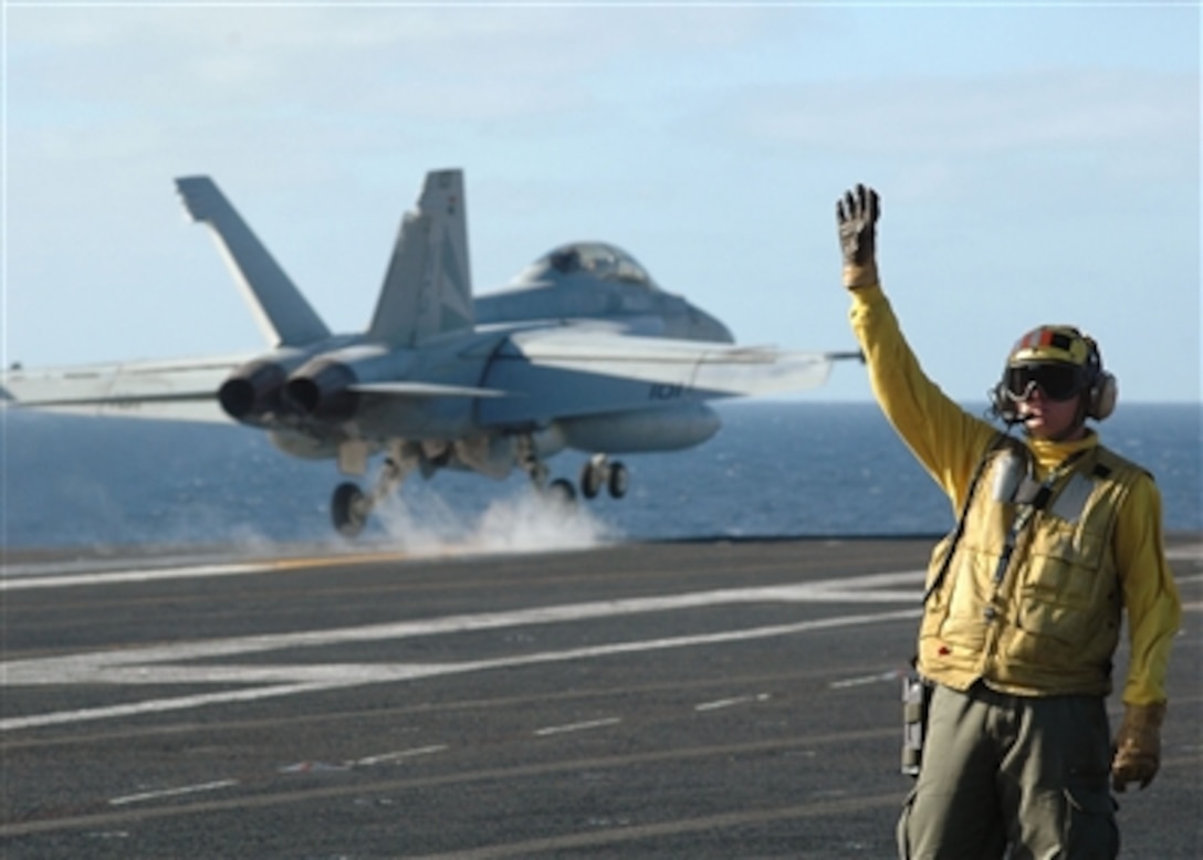 U.S Navy Petty Officer 2nd Class Daniel Lynn signals the safe launch of an F/A-18F Super Hornet aircraft during flight operations aboard the nuclear-powered aircraft carrier USS John C. Stennis (CVN 74) on Sept. 26, 2006.  The Stennis and embarked Carrier Air Wing 9 are operating during a composite training unit exercise.  Lynn is a Navy Aviation Boatswain's Mate.  