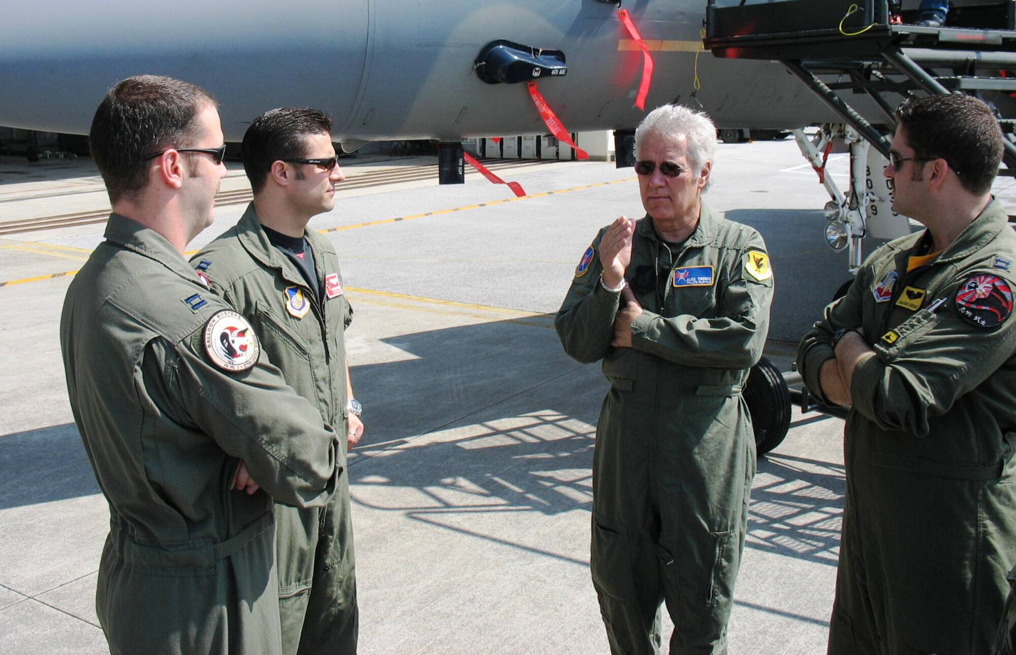 KADENA AIR BASE, Japan -- Alex Trebek, host of the Jeopardy game show, talks to U.S. Air Force fighter pilots at Kadena March 31 during a Jeopardy game show USO tour of Japan.  Speaking with Mr. Trebek are (from left) Capt. Phil Colomy, F-22 pilot with the 27th Fighter Squadron, Langley Air Force Base, Va.; Capt. Kirby Enser, F-15 pilot with the 67th Fighter Squadron, Kadena Air Base; and Capt. Jonathan Airhart, also an F-22 pilot with the 27th Fighter Squadron.  The two Langley pilots are here on the F-22 stealth fighter's first overseas deployment.  During the Jeopardy show's two-day trip to Kadena, Mr. Trebek and show staff also toured an F-22, a KC-135 Stratotanker, an E-3 AWACS (Airborne Warning and Control System), an F-15C fighter, and an HH-60 helicopter.  The F-22 is temporarily based at Kadena on its first overseas deployment from Langley Air Force Base, Va.  Kadena residents were allowed to try-out to be contestants on Jeopardy, as well.  (Air Force/Senior Master Sgt. Kenneth Fidler)