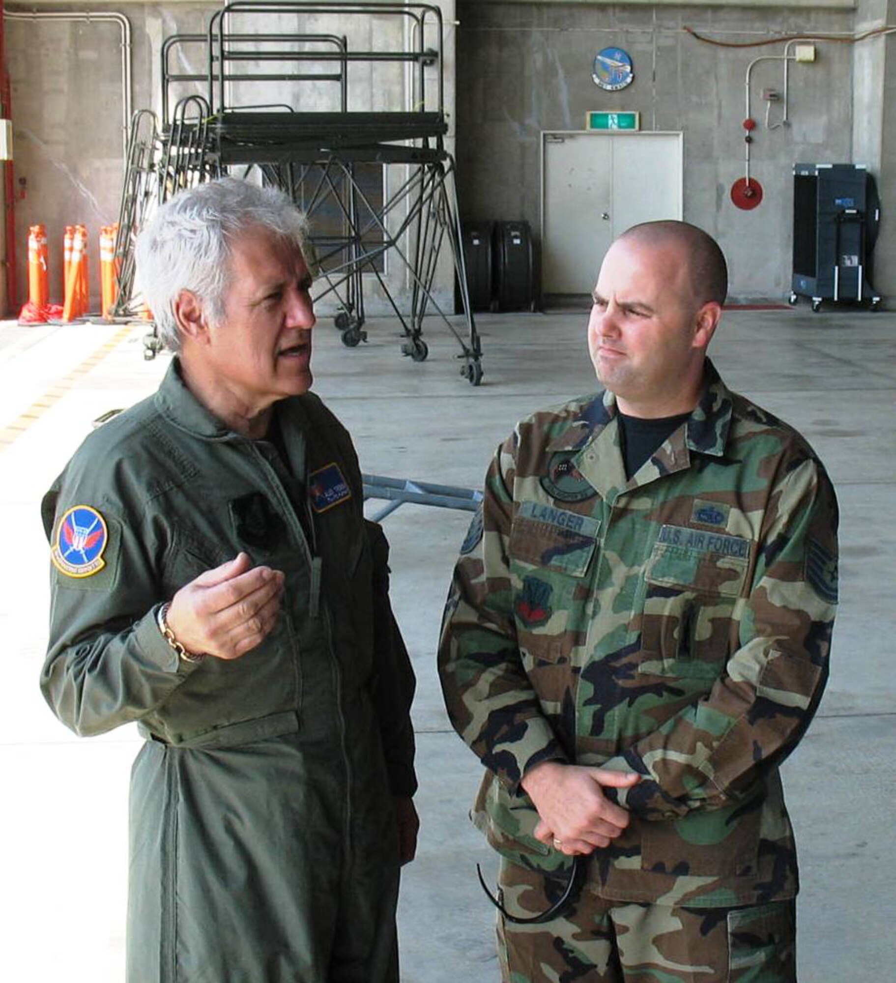 KADENA AIR BASE, Japan -- Alex Trebek, host of the Jeopardy game show, talks with Air Force Tech. Sgt. Mark Langer March 31 during a Jeopardy game show USO tour of Japan.  Sergeant Langer is deployed here with the 27th Fighter Squadron from Langley Air Force, Va., on the F-22 stealth fighter's first overseas deployment. During a two-day trip to Kadena, Mr. Trebek and Jeopardy show staff also toured an F-22, a KC-135 stratotanker, an E-3 AWACS (Airborne Warning and Control System), an F-15C fighter, and an HH-60 helicopter.  The F-22 is temporarily based at Kadena on its first overseas deployment from Langley Air Force Base.  Kadena residents were allowed to try-out to be contestants on Jeopardy, as well.  (Air Force/Senior Master Sgt. Kenneth Fidler)