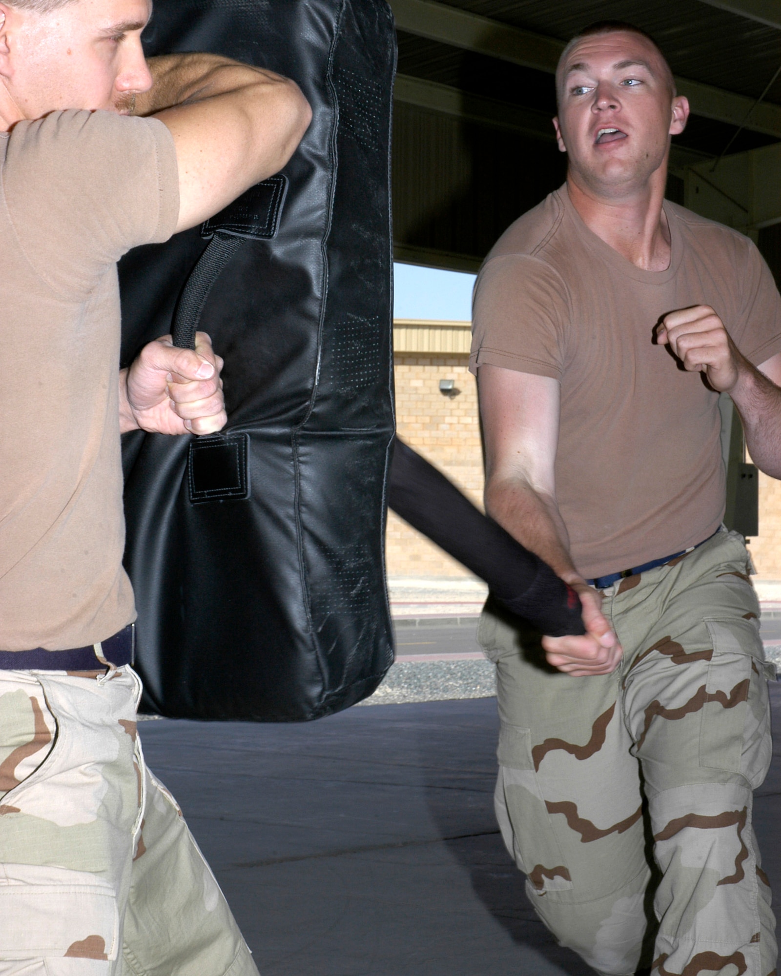 Senior Airman John Chiki (left) and Airman 1st Class James McGrath, force protection members with the 386th Air Expeditionary Wing, take part in a personal defense class held March 30 in Southwest Asia. All 386th AEW force protection personnel are trained in the use of the ASP, an extending baton used by police and security forces. (U.S. Air Force photo/Staff Sgt. Ian Carrier) 