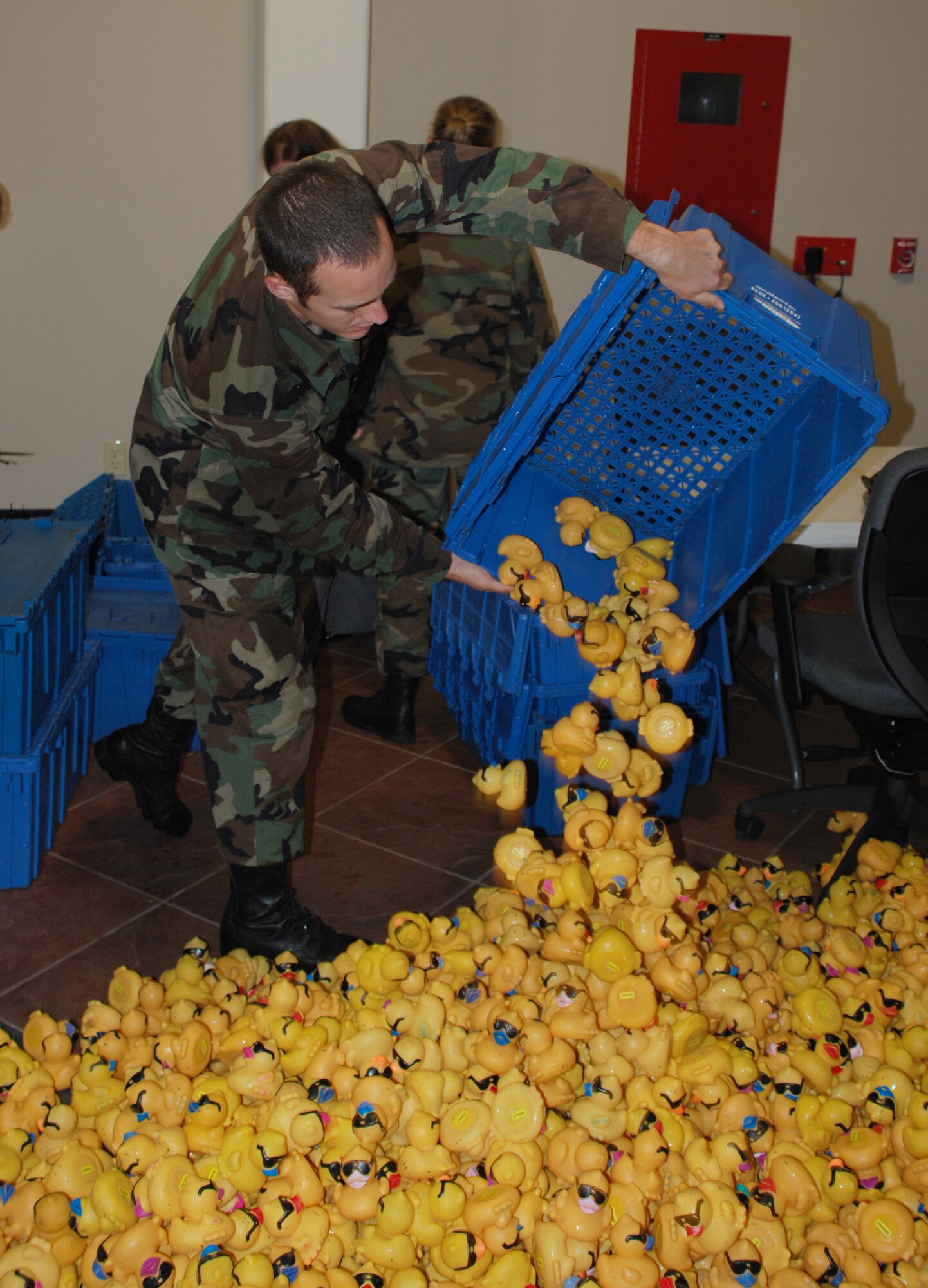 2nd Lt. Gabriel Gassie, pilot-in-trainig in casual status with the 80th Operations Support Squadron, empties a container of rubber ducks for cleaning and numbering March 30. The 80th OSS teamed up with their squadron adopter, the United Regional Foundation, to ready the ducks for the inaugural Rubber Duck River Derby April 14. (U.S. Air Force photo/Airman 1st Class Jacob Corbin)