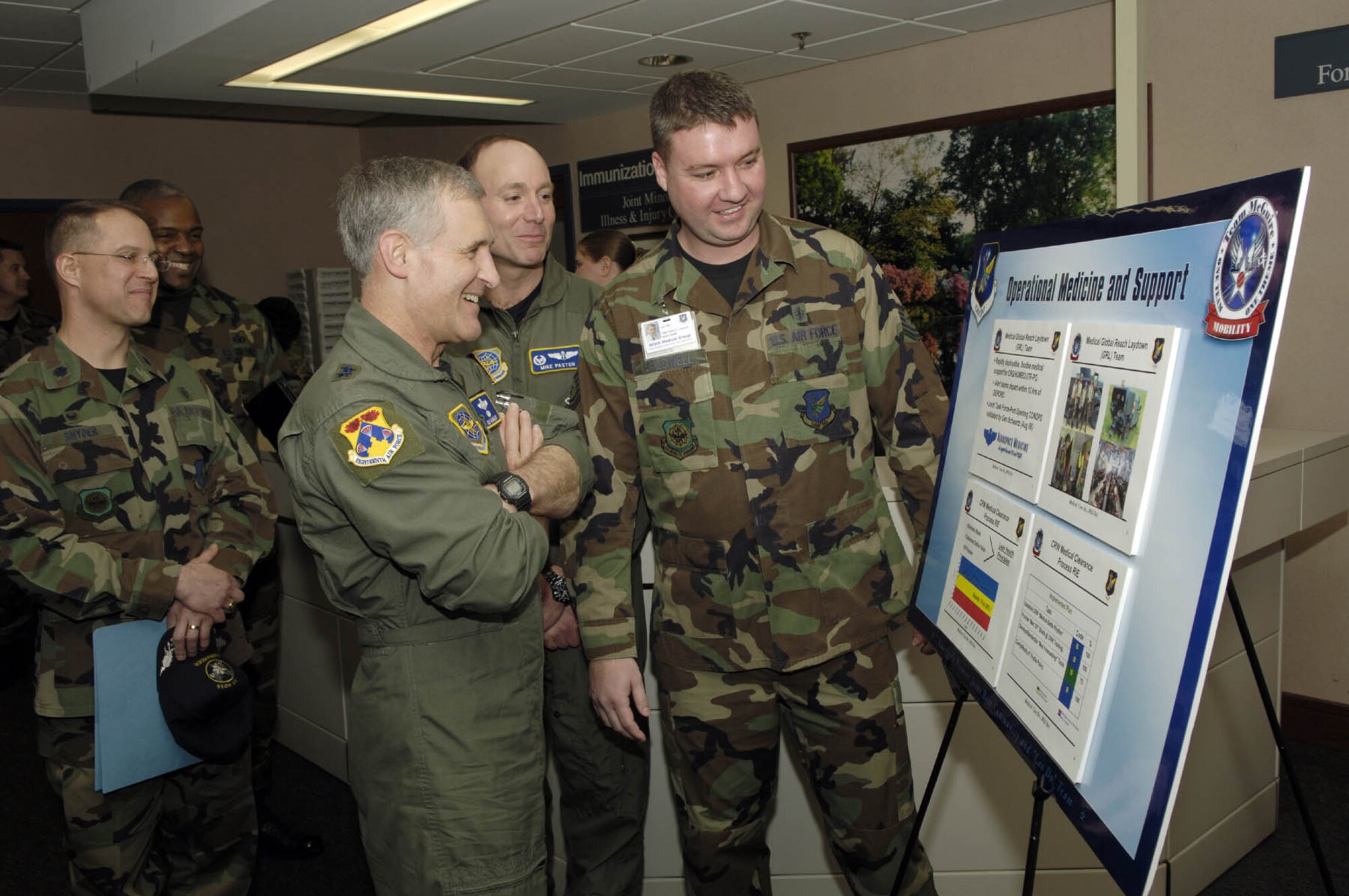 Members of the 305th Medical Group show Maj. Gen. James Hawkins, 18th Air Force commander, a display board on operational medicine and support at the 305th Medical Group Clinic March 23. The clinic was one of the places the general visited during his two-day official visit here March 22-24. 