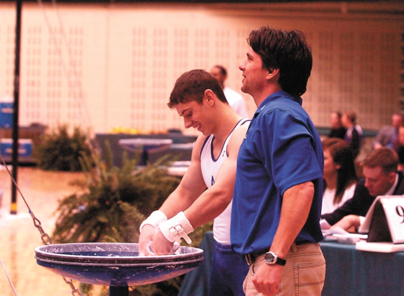 Head Coach Kip Simons talks with Air Force Academy junior Greg Stine as he chalks up for his next event at the United States of America Gymnastics championships held at the College of Wililam & Mary in Williamsburg, Va., March 24 and 25. (Military Newspapers of Virginia photo/Harry Gerwien)