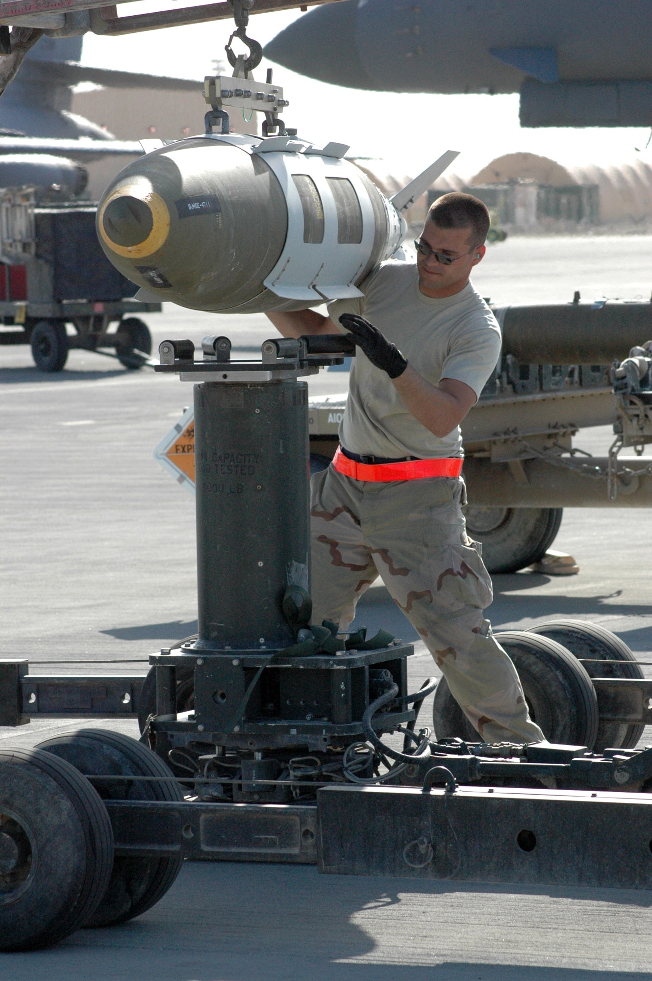 Weapons load crew member, Airman 1st Class Kenneth Nealis, transfers a 2,000-pound GBU-31 Joint Direct Attack Munition from one lift truck to another for transport and loading onto a B-1B Lancer. Airman Nealis is assigned to the 379th Expeditionary Aircraft Maintenance Squadron in support of Operation Iraqi Freedom and Operation Enduring Freedom in Afghanistan. (U.S. Air Force photo/Senior Airman Erik Hofmeyer) 
