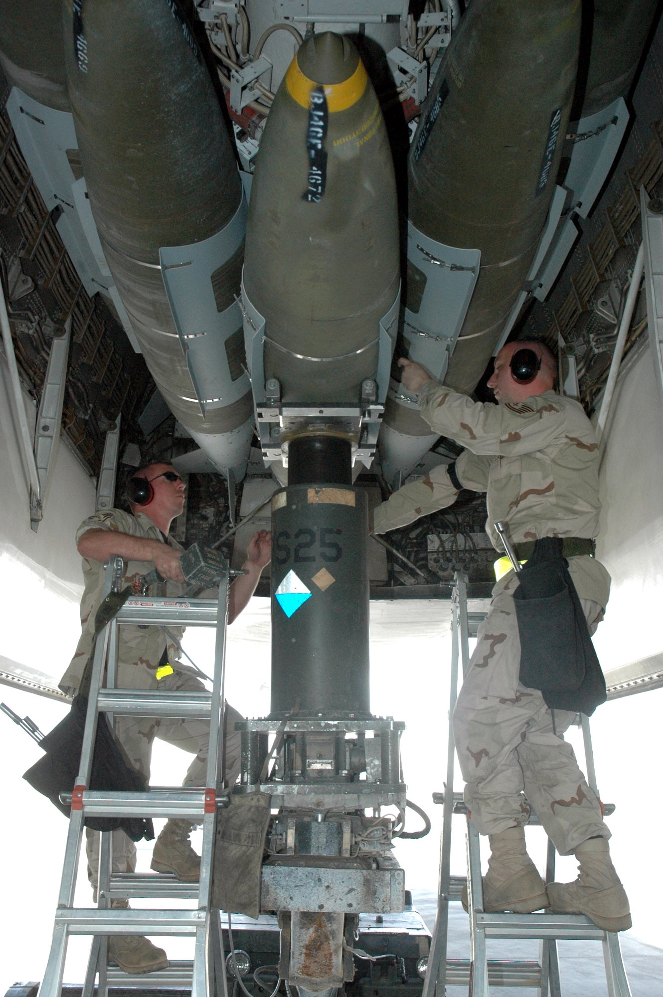 Weapons load crew members, Staff Sgt. Kevin Rayburn (left) and Tech. Sgt. Jeff Allen,  load a 2,000-pound GBU-31 Joint Direct Attack Munition hoisted up by a MJ-40 lift truck March 28 onto a B-1B Lancer. The Airmen are assigned to the 379th Expeditionary Aircraft Maintenance Squadron in support of Operation Iraqi Freedom and Operation Enduring Freedom in Afghanistan. (U.S. Air Force photo/Senior Airman Erik Hofmeyer) 
