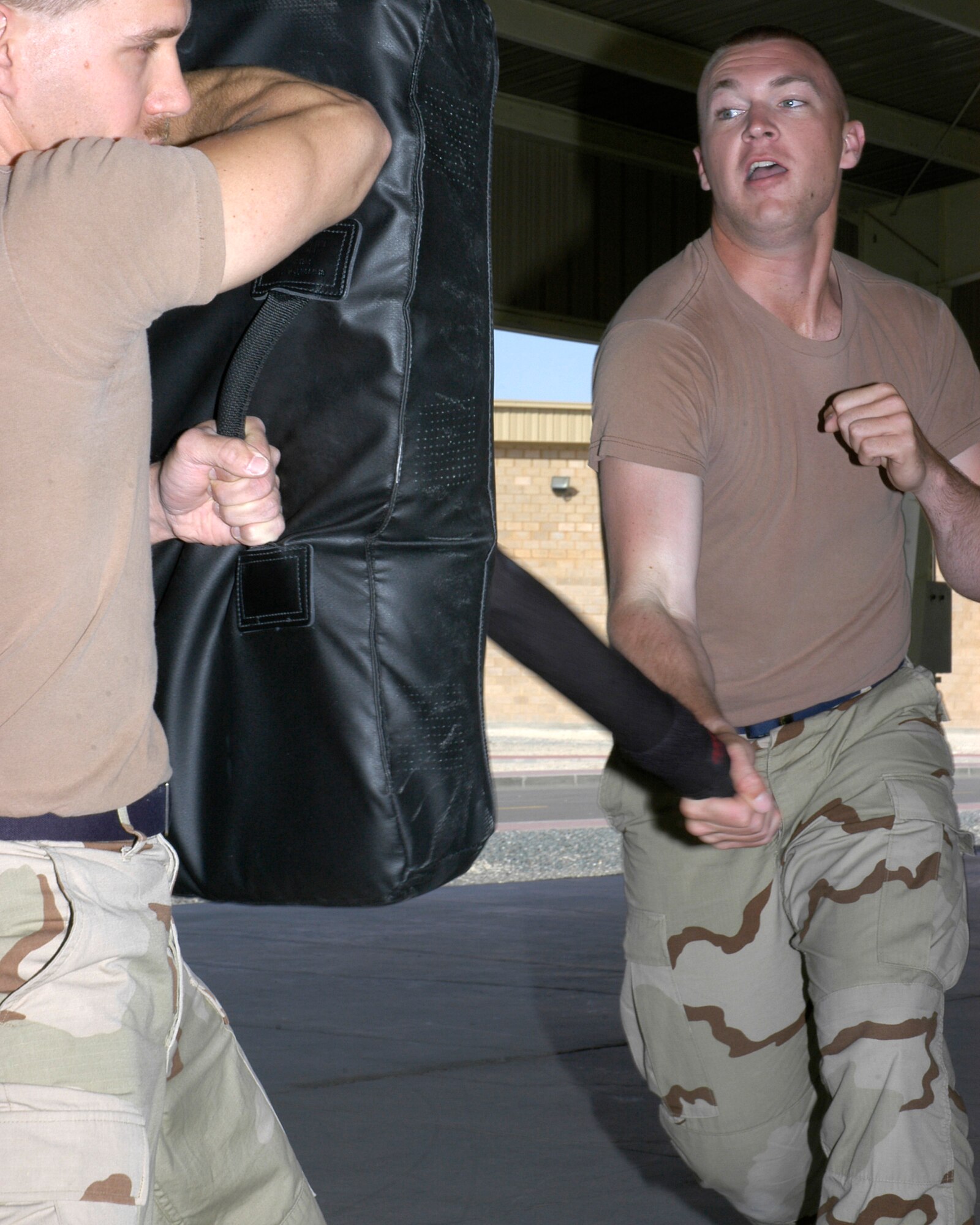 SOUTHWEST ASIA -- Senior Airman John Chiki, left, and Airman 1st Class James McGrath, assigned to the 386th Expeditionary Security Forces Squadron, received ASP training.  A1C McGrath demonstrates an open mode weapon side strike.  The personal defense course taught Security Forces personnel how to use a less than lethal weapon to defend themselves.  Classes were held on March 29th and 30, 2007.  65 personnel assigned to the Security Forces Squadron received the training.  (AF photo/ Staff Sgt. Ian Carrier)   