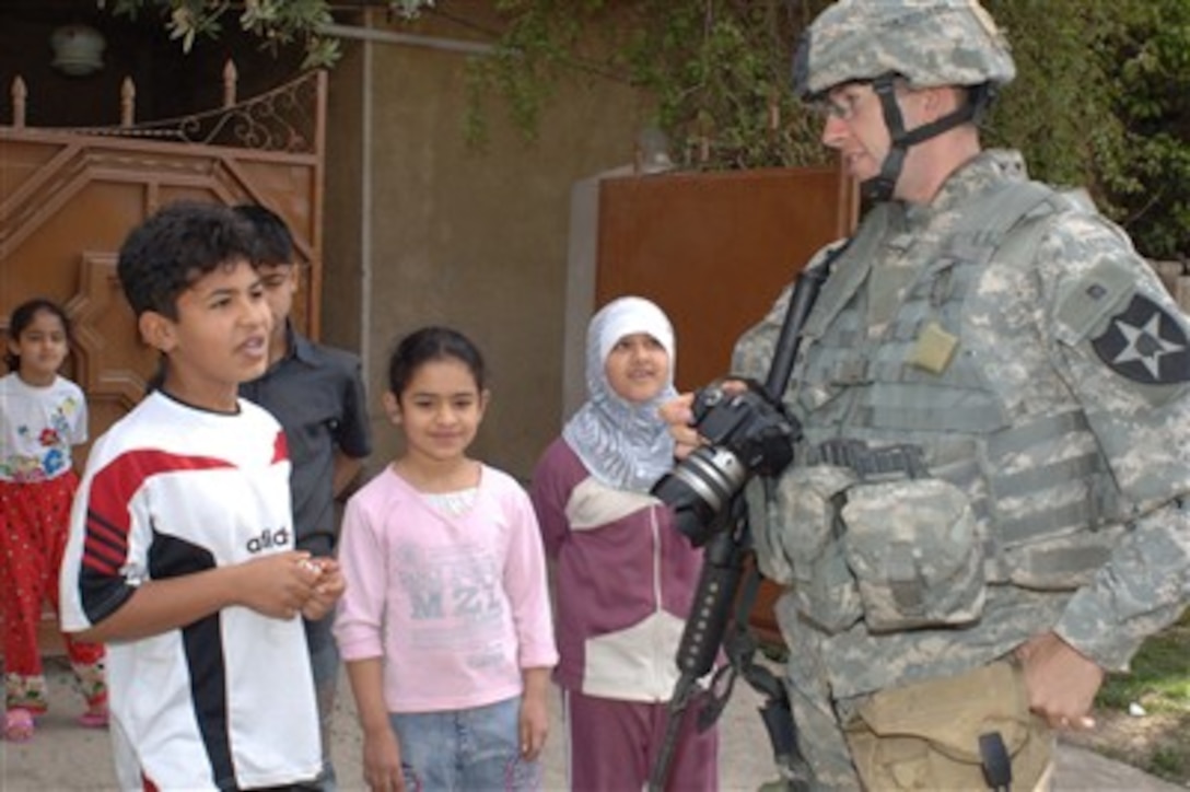 A U.S. Army soldier from 2nd Battalion, 17th Field Artillery Military Transition Team, talks to Iraqi children in the Rusafa area of East Baghdad, Iraq, March 27, 2007, during a combined cordon and search operation with members of 3rd Battalion, 8th Brigade, 2nd Iraqi National Police Division.