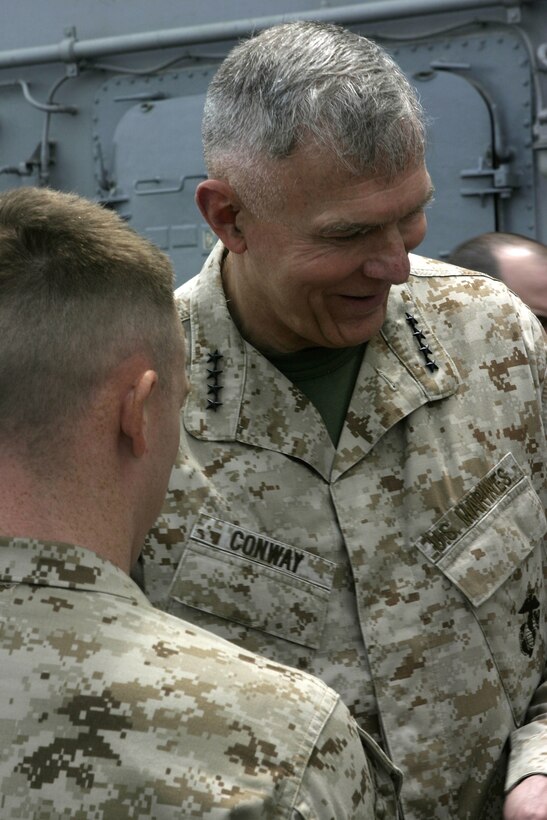 Gen. James T. Conway, Commandant of the Marine Corps, pins sergeant chevrons on Timothy A. Foster, Company E, Battalion Landing Team 2/2, during a promotion ceremony on the flight deck of the USS Bataan, April 4.  Conway and Sgt. Maj. John L. Estrada, Sergeant Major of the Marine Corps, visited with Marines and Sailors aboard USS Bataan, Oak Hill and Shreveport to discuss the 26th Marine Expeditionary Unit's current deployment.