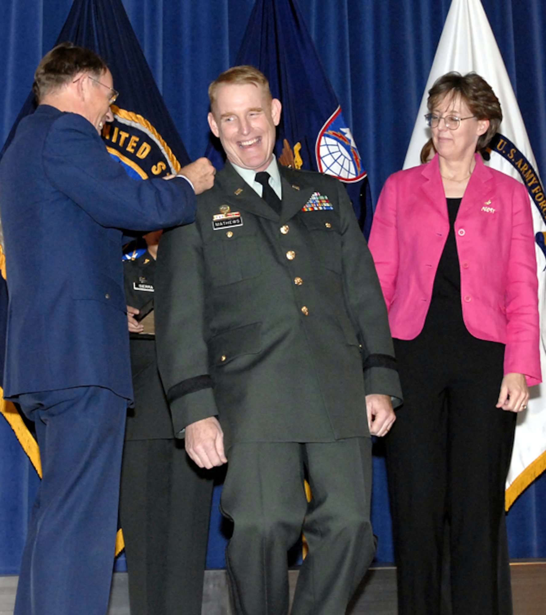 Col. Roger F. Mathews (center) is pinned with the stars of a brigadier general by his wife Connie (right) and his father retired Air Force Col. Bruce Mathews (left) during April 2 ceremonies held at the Peterson auditorium. Mathews is the deputy commanding general for Operations at the U. S. Army Space and Missile Defense Command/U. S. Army Forces Strategic Command. (U.S. Army photo by Erica M. Belcher)