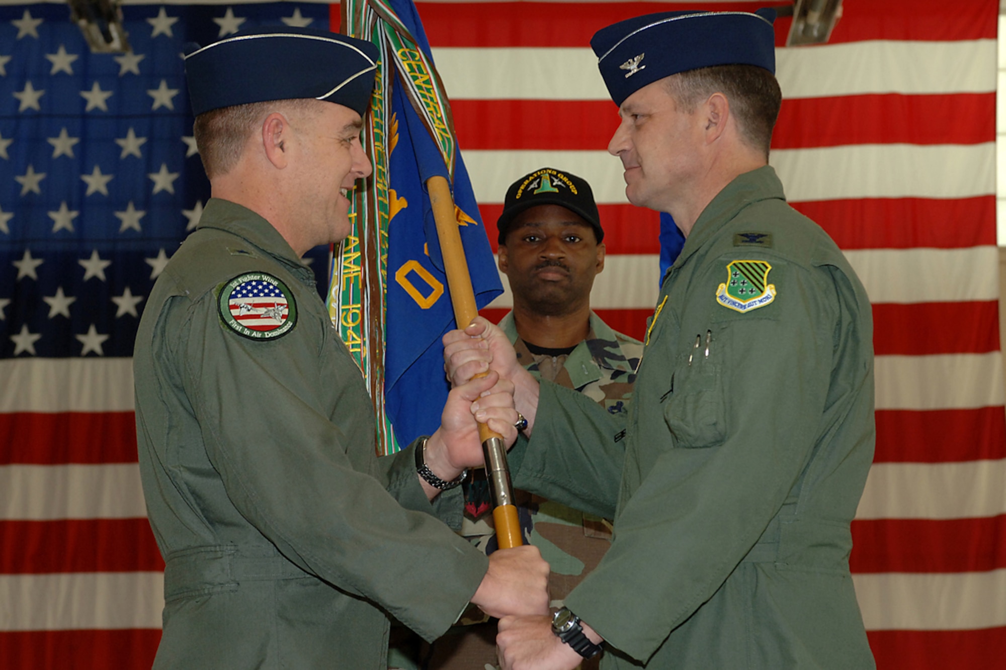 Brig. Gen. Burt Field, 1st Fighter Wing commander, presents the guidon to Colonel Patrick Marshall during the 1st Operations Group change of command ceremony March 30 here. Colonel Marshall assumed command of the group from Colonel Tom Bergeson. (U.S. Air Force Photo/Senior Airman Michelle Arslan)