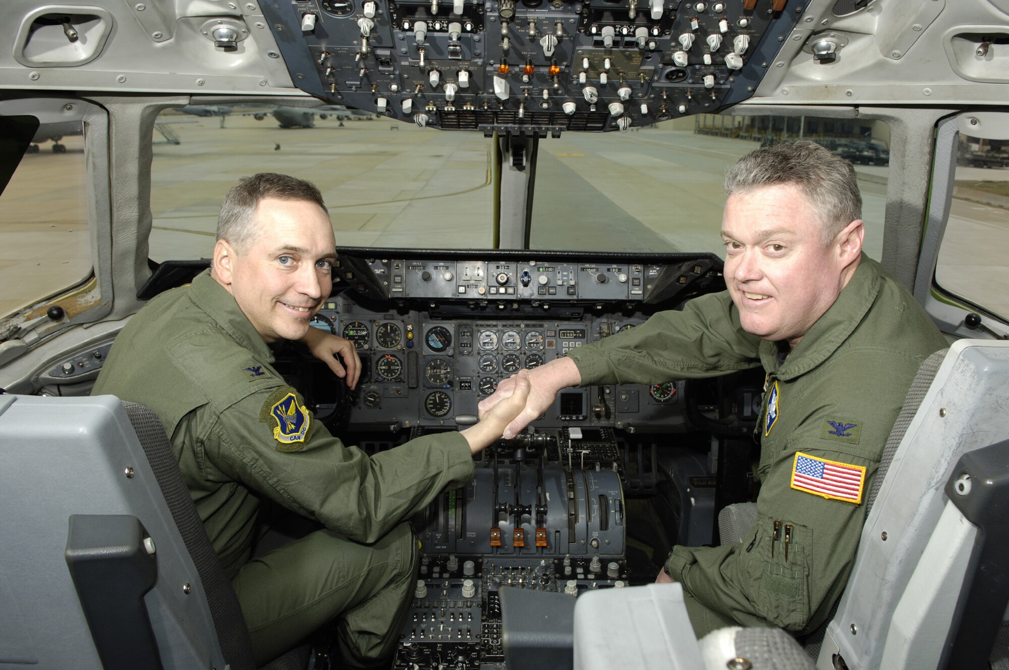Col. Rick Martin, 305th Air Mobility Wing Commander, and Col. James Kerr, 514th Air Mobility Wing Commander, demonstrate a visible partnership together in the flight deck of a McGuire KC-10 aircraft. The active duty and reserve wings have enjoyed successful Total Force Integration since 1968. Total Force Integration at McGuire Air Force Base is a seamless operation where the 305th and 514th Air Mobility Wings share personnel, equipment, facilities and supplies to support a common mission. (U.S. Air Force photo/Ken Mann) 