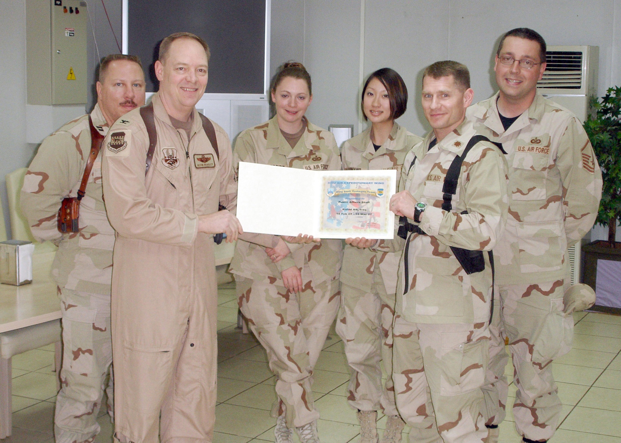BALAD AB, Iraq— Col. Kevin Bradley, 332nd Air Expeditionary Wing Director of Staff, presents the March 2007 Wing Staff Team of the Month award to the 332nd AEW Public Affairs office staff.  From left to right: Capt. Ken Hall, Col Bradley, Senior Airman Candace Romano, Tech. Sgt. Jennifer Gregoire, Maj. Damien Pickart and Master Sgt. Bryan Ripple. Sergeant Ripple is currently deployed from the 910th Airlift Wing, Youngstown Air Reserve Station, where he serves as the Deputy Chief of the Public Affairs office. The staff was recognized for their efforts to communicate the wing's mission at the Air Force's premier combat airpower hub in Iraq.     