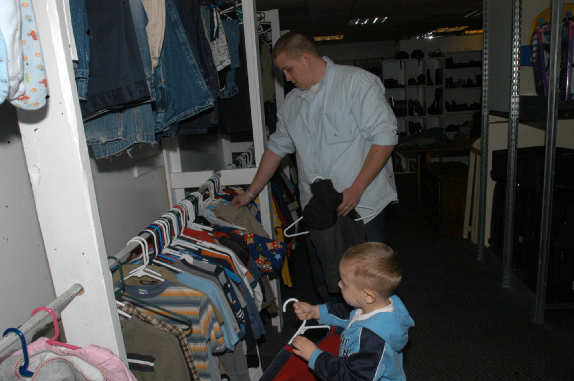 Jeremy Ferguson and his son Zachary, age 3, shop the clothes selection at the Airmen's Attic, RAF Lakenheath. (U.S. Air Force photo by Jill Fuson)