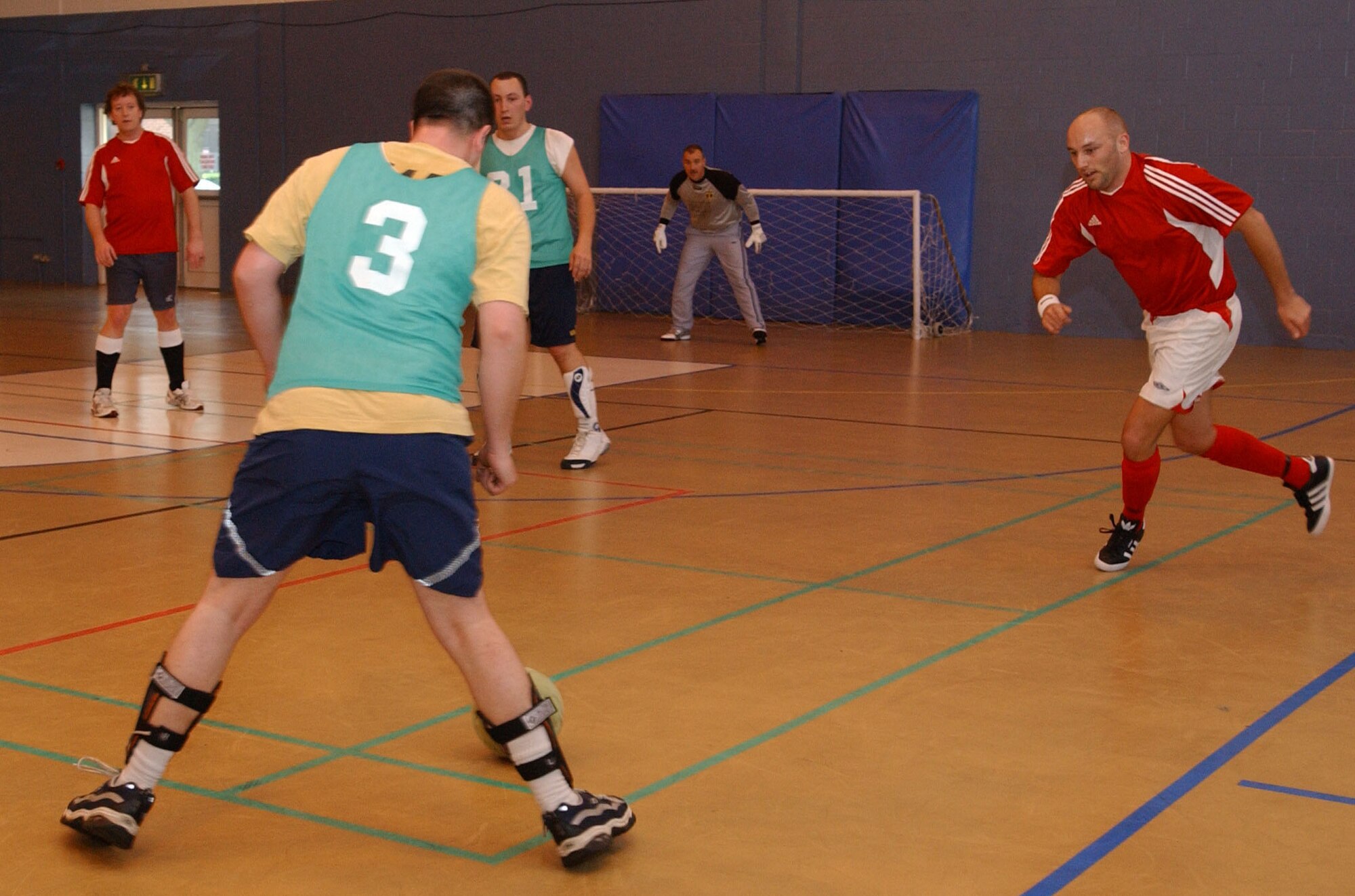 Jake Christensan, 100th Logistics Readiness Squardron, attacks the goal while Pete Webb, 727th Air Mobility Squardron, goes to close him down during an indoor soccer game at the Northside fitness center April 2, 2007. (U.S. Air Force photo by Airman Brad Smith)