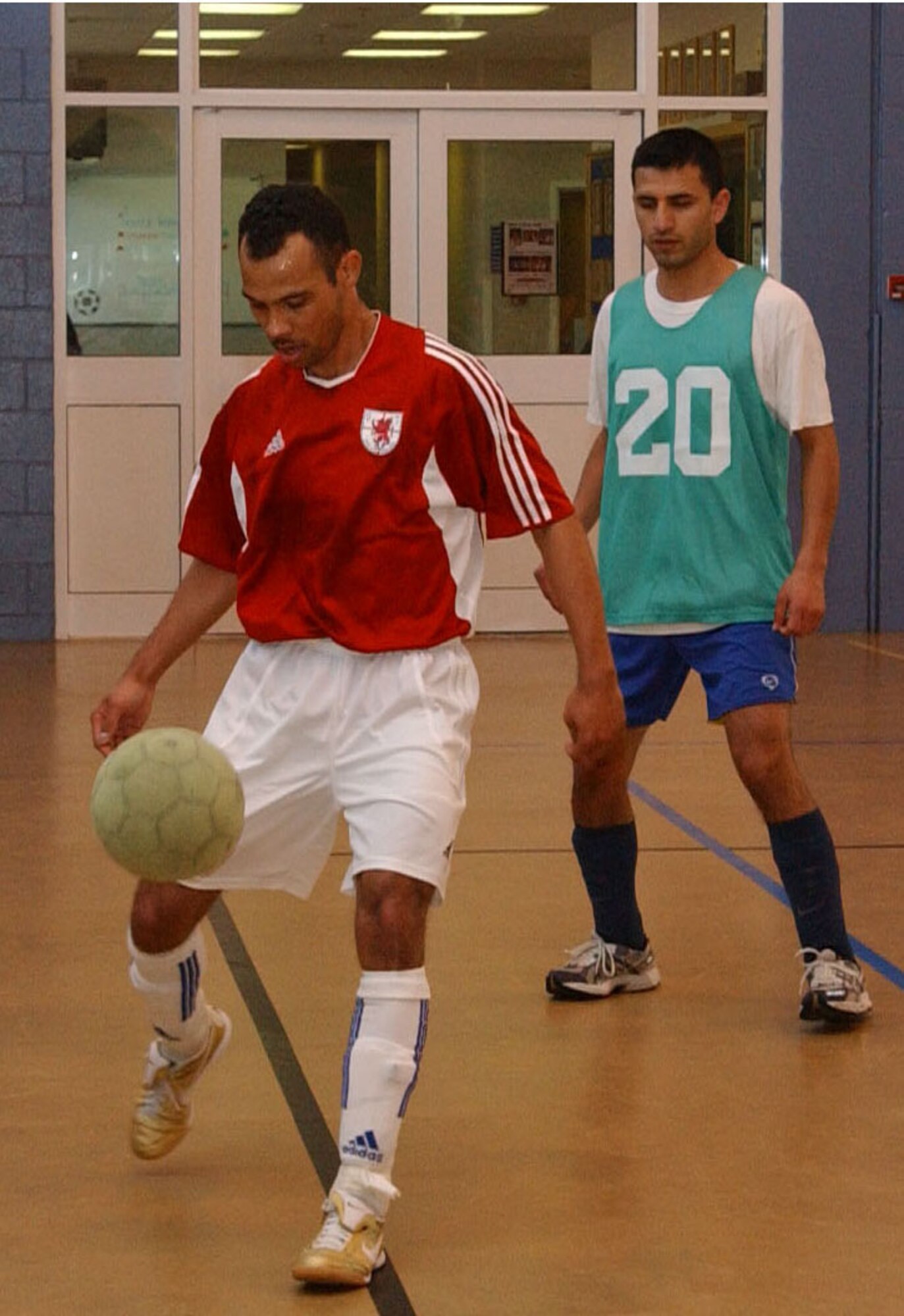 Oscar Figueroa, 100th Logistics Readiness Squardron looks on while Mike Dedousis, 727th Air Mobility Squardron controls the ball April 2, during an indoor soccer game at RAF Mildenhall's Northside fitness center. (U.S. Air Force photo by Airman Brad Smith)