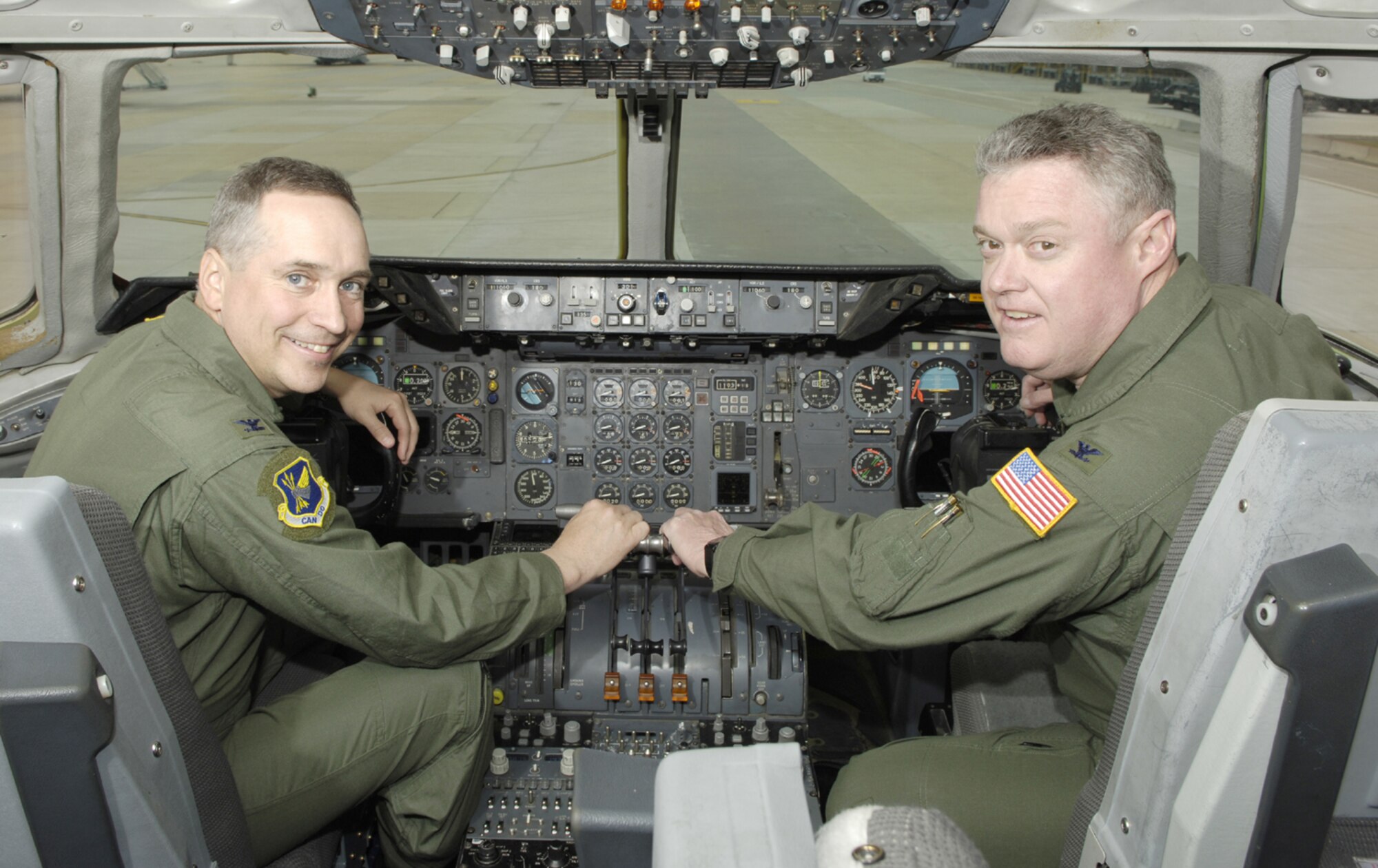 Col. Rick Martin, 305th Air Mobility Wing commander, and Col. James Kerr, 514th Air Mobility Wing commander, pose together in the cockpit of a McGuire KC-10 to emphasize the Total Force partnership between the active-duty and Reserve wings.