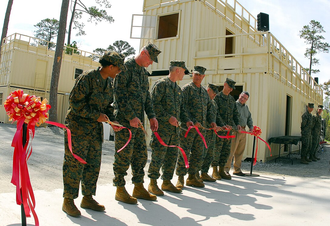 MARINE CORPS BASE CAMP LEJEUNE, N.C. - Col. Adele E. Hodges, commanding officer of Marine Corps Base, Brig. Gen. James B. Laster, the commanding general of Training Command, Lt. Gen. James F. Amos, the commanding general of Marine Corps Combat Development Command, Maj. Gen. Robert C. Dickerson, the commanding general of Marine Corps Installations East, Col. Thomas C. Cariker, the chief of staff for II Marine Expeditionary Force, Col. Walter H. Augustin, the program manager for Training Systems, Marine Corps Systems Command and Jack Cuddy, the director for Range and Training Area Management Division, Training and Education Command, cut the ribbon for the Mobile Military Operations in Urban Terrain Facility here officially unveiling it April 3.