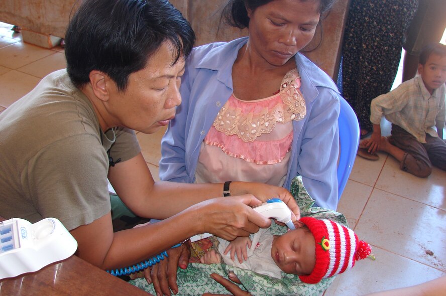 CAMBODIA - Lt Col Diep Duong, nurse and team leader with Pacific Air Forces International Health Affairs team, obtains temperature on a Cambodian newborn presented for care at Snoul MEDCAP site.  The Pacific Air Forces International Health Specialist team left here Jan. 9 for a medical mission in Cambodia to conduct a Humanitarian Civic Assistance and Subject Matter Expert Exchange.  (Photo by John P. Spickelmier)
