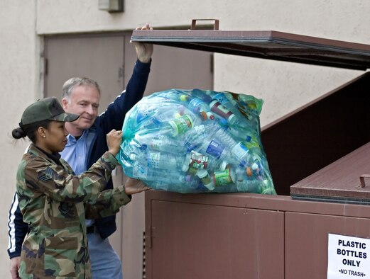 OSAN AIR BASE, Republic of Korea -- Mr. Ahmet Turkoglu, 51st Civil Engineering environmental flight, helps a customer place recyclables into a trash container. Under Osan's new recycling program, cans, paper and plastic can be placed in a clear blue bag and placed in any trash container on base or taken to the hazardous waste storage facility, Bldg. 833, in order to be recycled. Additionally, cardboard and wooden pallets can also be taken to Bldg. 833 to be recycled. For more information about Osan's recycling program, call the 51st CES environmental flight at 784-4272. (U.S. Air Force photo by Master Sgt. Ben Huseman) 