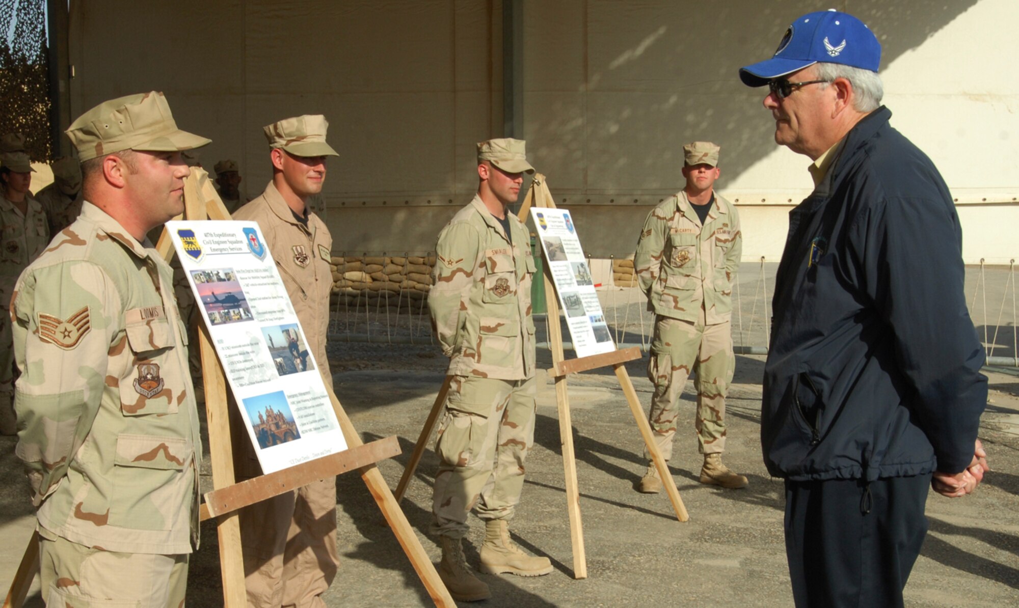 Staff Sgt. Daniel Loomis (left, front), an explosive ordnance disposal technician from D-M, along with Senior Airman Jacob McCarty, Airman Gregory Smialek and Senior Airman Ian Jackson, briefs Secretary of the Air Force Michael Wynne (right, front) on the EOD mission within the 407th Air Expeditionary Group. The Airmen used story boards to help highlight the EOD accomplishments during the current AEF rotation. 
