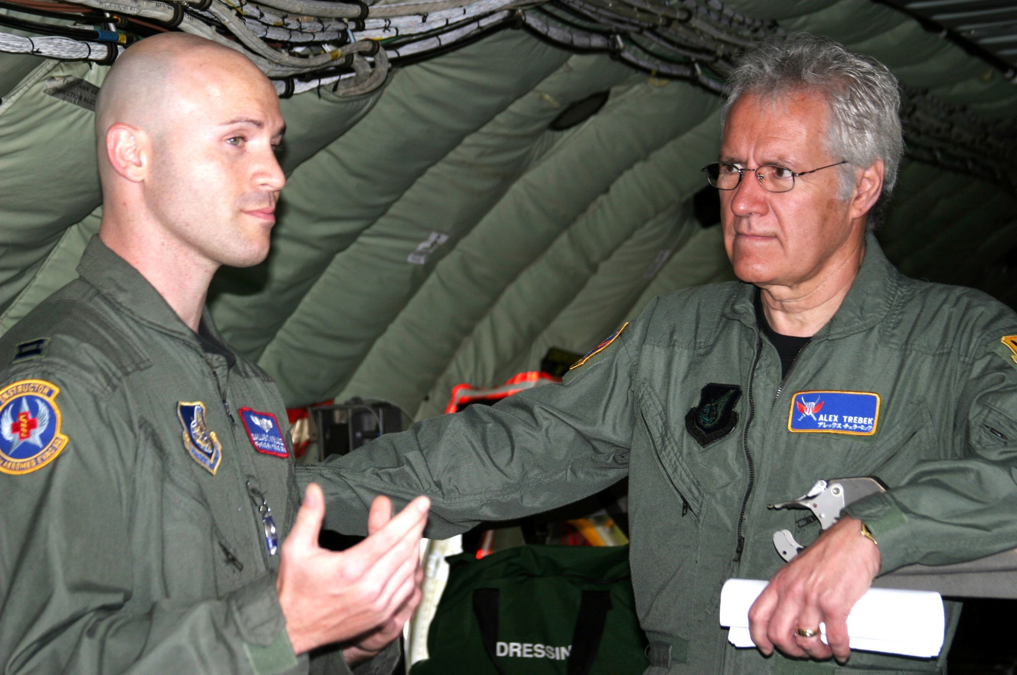 Alex Trebek listens as Capt. Dallas Weills explains how KC-135 Stratotankers can fly critical-care patients to hospitals in the United States March 31 at Kadena Air Base, Japan. Captain Weills is an in-flight medic with the 18th Aeromedical Evacuation Squadron. During a two-day "Jeopardy" USO tour to Kadena March 30 and 31, the host of the "Jeopardy" show and the staff toured an F-22 Raptor, KC-135 Stratotanker, E-3 Sentry, F-15 Eagle, and an HH-60 Pave Hawk. Kadena AB residents were allowed to try-out to be contestants on "Jeopardy." (U.S. Air Force photo/Senior Airman Nestor Cruz)
