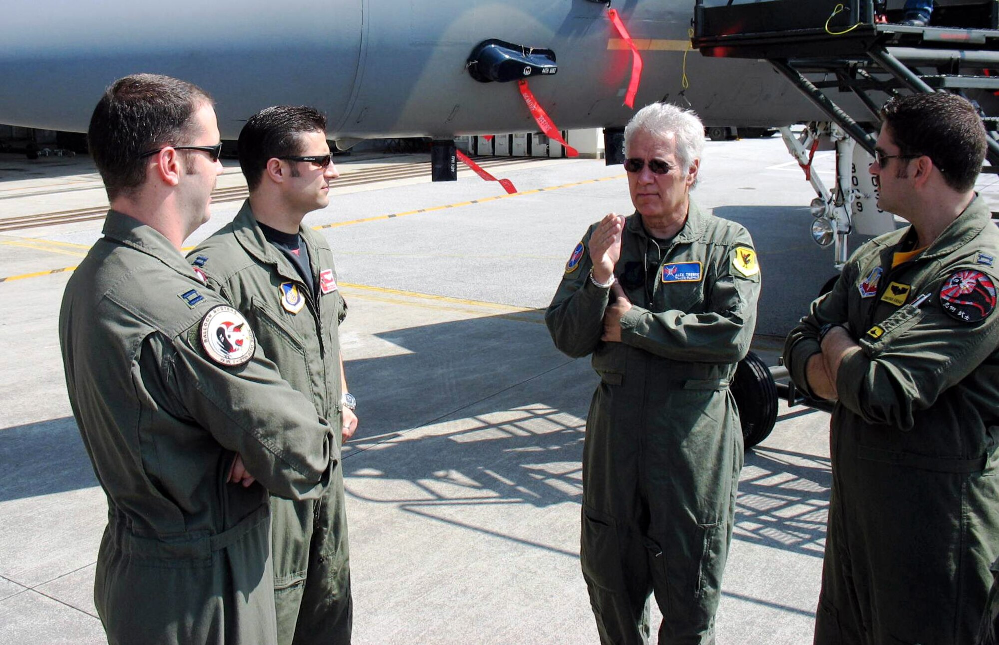 Alex Trebek (second from right) talks to (from left) Capt. Phil Colomy, Capt. Kirby Enser and Capt. Jonathan Airhart during a "Jeopardy" game show USO tour of Japan March 31 at Kadena Air Base, Japan. The host of the "Jeopardy" game show and the show's staff toured an F-22 Raptor, KC-135 Stratotanker, E-3 Sentry, F-15 Eagle, and an HH-60 Pave Hawk during the two-day visit to Kadena AB. Captain Colomy and Captain Airhart are F-22 pilots with the 27th Fighter Squadron at Langley Air Force Base, Va., and Captain Enser is an F-15 pilot with the 67th Fighter Squadron at Kadena AB. The F-22 is temporarily based at Kadena AB on its first overseas deployment from Langley AFB. Kadena AB residents were allowed to try-out to be contestants on "Jeopardy." (U.S. Air Force photo/Senior Master Sgt. Kenneth Fidler)
