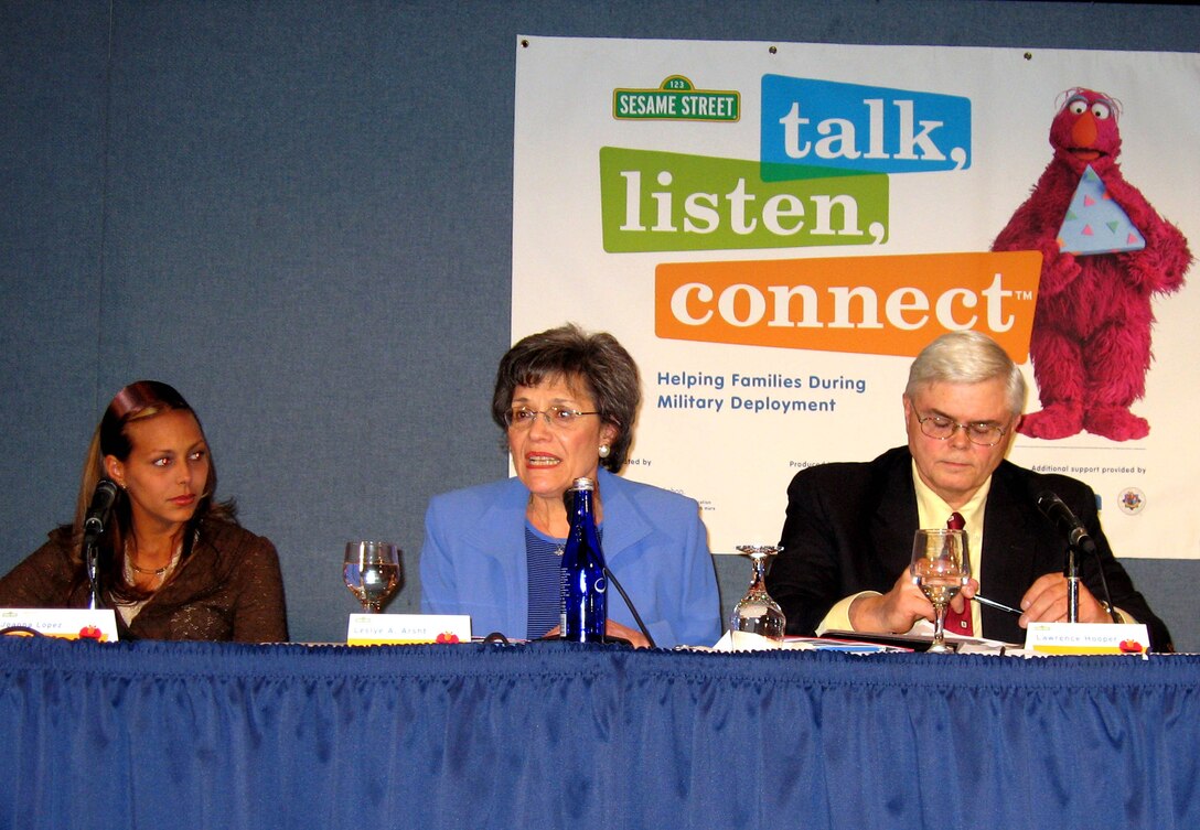 Leslye Arsht, deputy under secretary of defense for military community and family policy, center, tells a crowd gathered at the National Press Club in Washington about the positive impact the Sesame Workshop's "Talk, Listen, Connect: Helping Families During Military Deployment" and the associated tool kit has had on military families. Joanna Lopez, left, and her three children are featured on a DVD included in kit. Lawrence Hooper, right, is a partner with Russell Research, Inc., which conducted a study of the kit’s impact. Defense Photo by Samantha L. Quigley