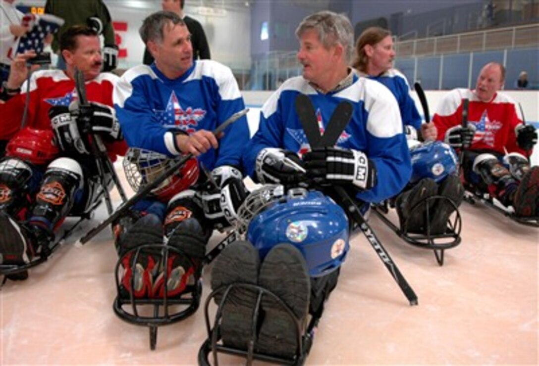 Secretary of Veterans Affairs R. James Nicholson, right,  takes a moment to talk to a fellow player after a game of sled hockey during the National Disabled Veterans Winter Sports Clinic in Snowmass Village, Colo. April 3, 2007, 
