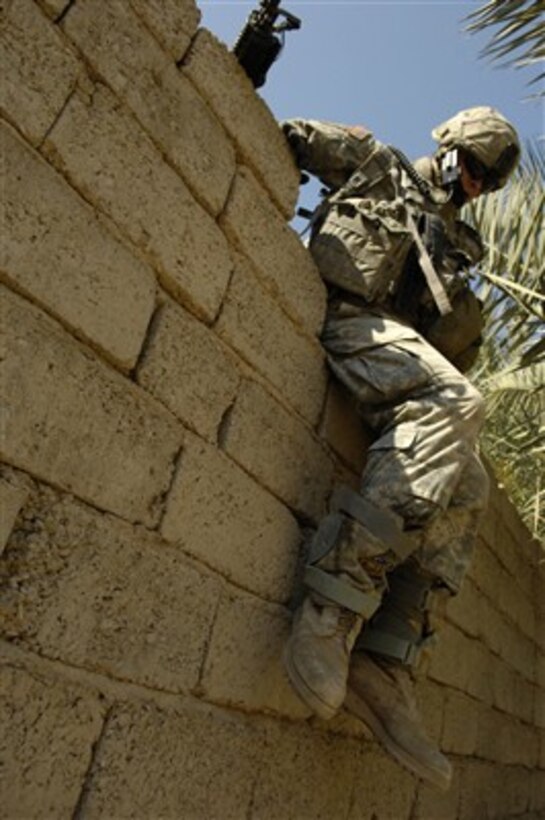 A U.S. Army soldier climbs over a wall to get to the next objective during an operation in Zaghiniyat, Iraq, on March 29, 2007.  Soldiers from Charlie Troop, 5th Squadron, 73rd Cavalry Regiment, 82nd Airborne Division, Fort Bragg, N.C., are on a mission to rid the area of insurgent forces and to allow coalition forces freedom of movement throughout the area.  