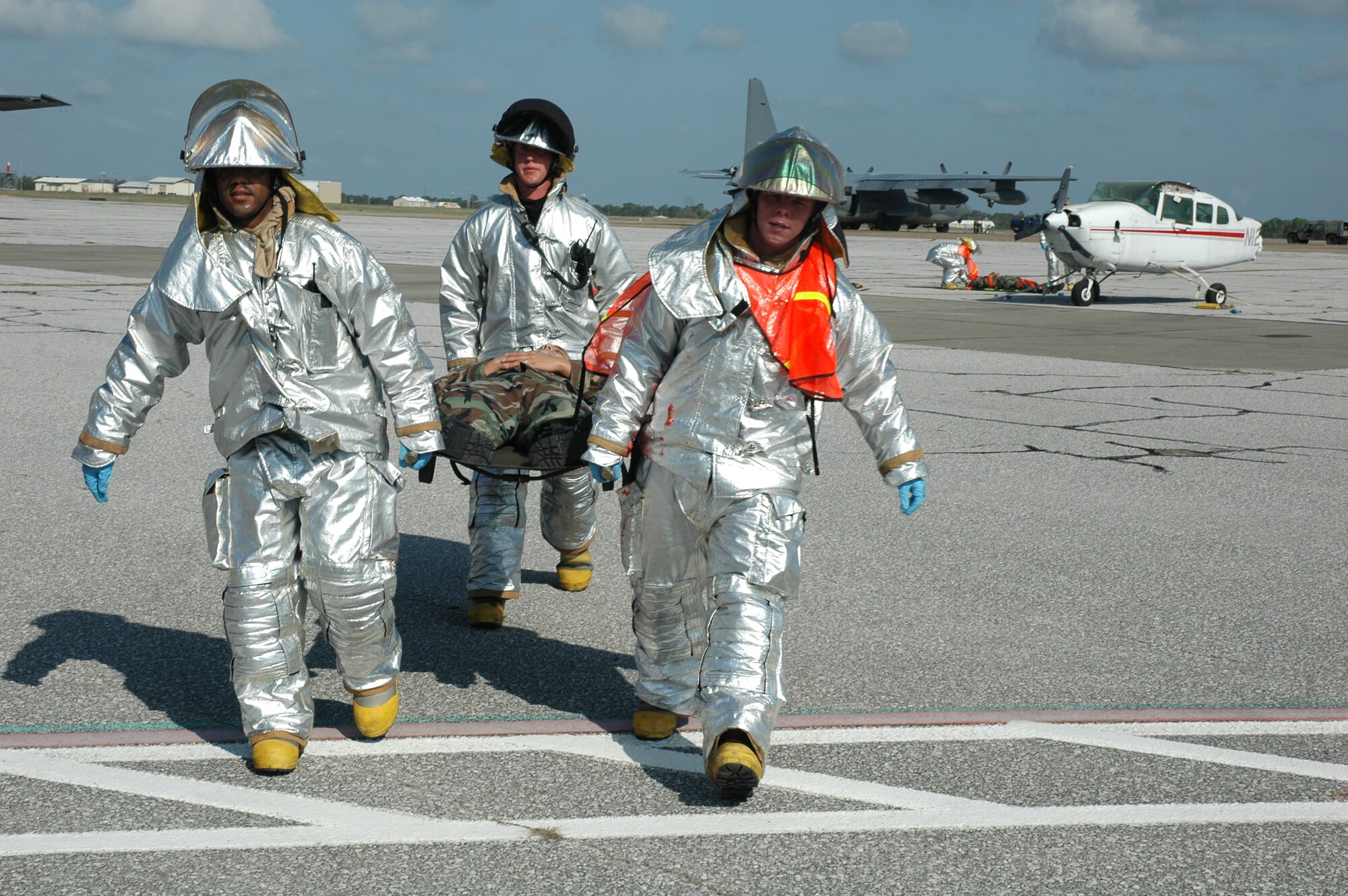 EGLIN AIR FORCE BASE, Fla. -- Eglin firemen carry a victim to the medical staging area during the major accident readiness exercise April 3 after responding to a simulated F-16 crash. The MARE was in preparation for the 2007 Eglin Air Show April 14-15. There were two other incidents that tested Eglin Airmen's emergency response capabilities: a vehicle borne chemical weapon attack and a bomb threat on a C-130 aircraft. (U.S. Air Force Photo by Staff Sgt. Mike Meares)