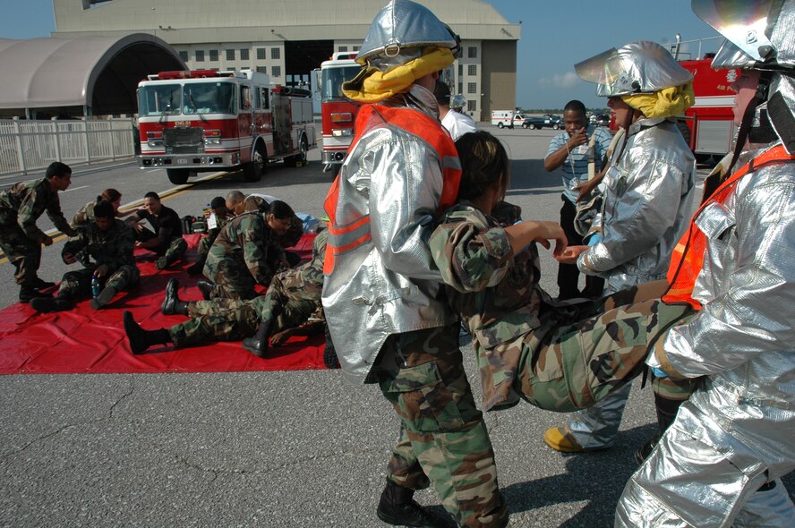 EGLIN AIR FORCE BASE, Fla. -- Eglin firemen carry a victim to the medical staging area during the major accident readiness exercise April 3 after responding to a simulated F-16 crash. The MARE was in preparation for the 2007 Eglin Air Show April 14-15. There were two other incidents that tested Eglin Airmen's emergency response capabilities: a vehicle borne chemical weapon attack and a bomb threat on a C-130 aircraft. (U.S. Air Force Photo by Staff Sgt. Mike Meares)