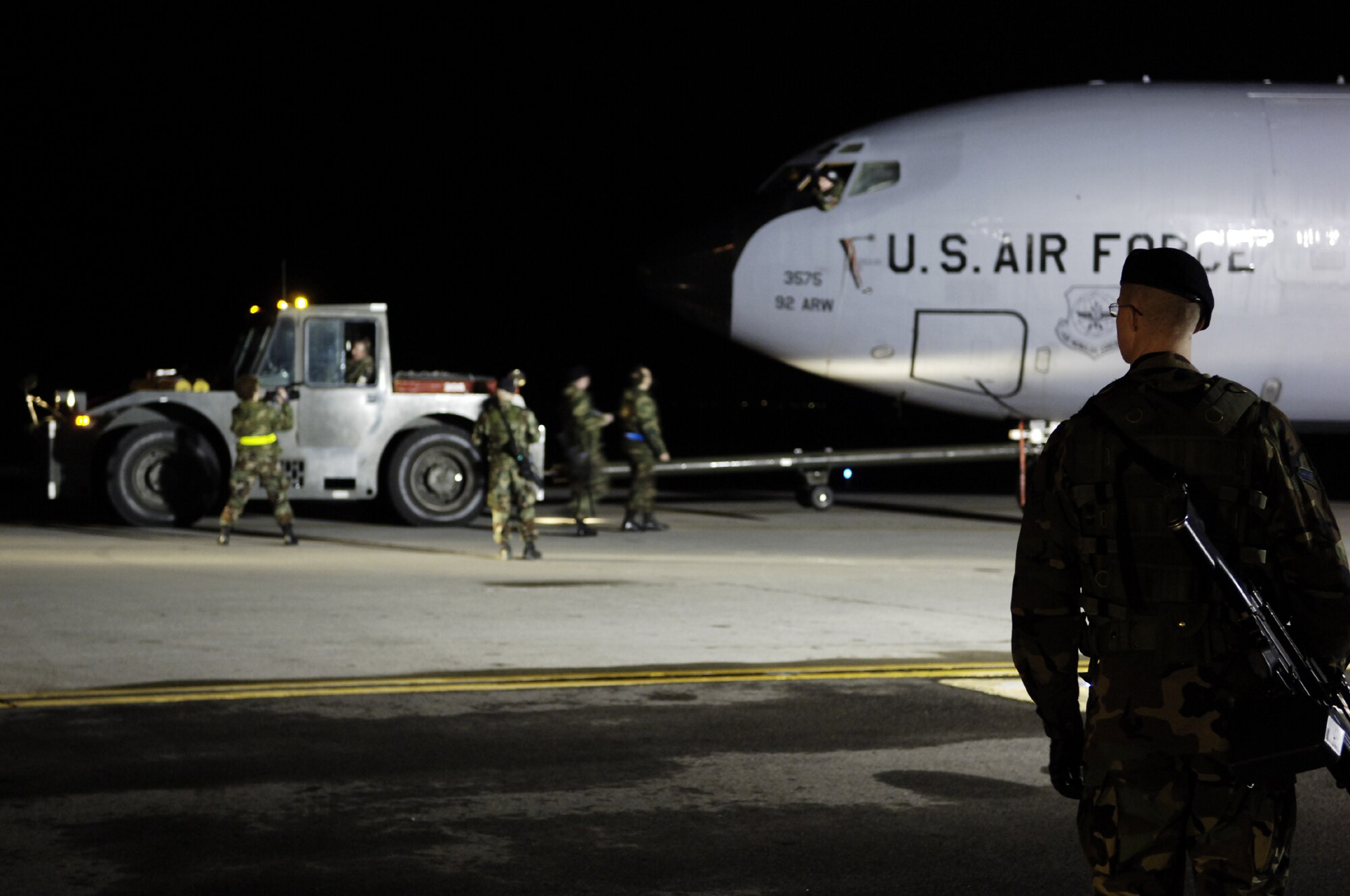 FAIRCHILD AIR FORCE BASE, Wash. - Airman 1st Class Samuel Warren (right), 92nd Security Forces Squadron, stands guard at an entry control point while members of the 92nd Maintenance Group tow a KC-135 “Stratotanker” into  a controlled area in preparation for an aircraft generation while participating in an exercise here recently. (U.S. Air Force photo/Senior Airman Anthony P. Ennamorato)
