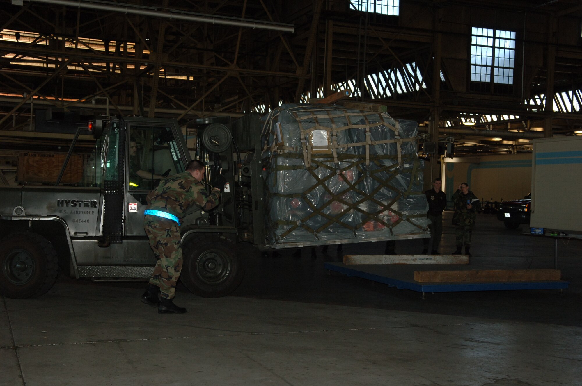 FAIRCHILD AIR FORCE BASE, Wash. - The 92nd Communications Squadron has their pallet weighed inside a hangar behind Building 2050 in preparation for an exercise. Members from the traffic management office use a forklift to place the pallet on a scale to be weighed while exercise evaluators watch. (U.S. Air Force photo/Airman 1st Class Jocelyn A. Ford)