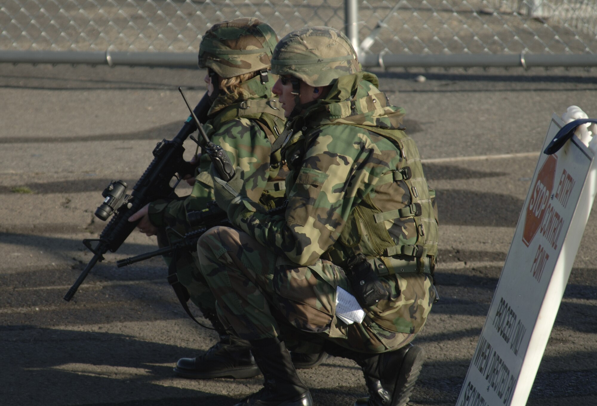 FAIRCHILD AIR FORCE BASE, Wash. - Staff Sgt. Jerimiah Brock and Staff Sgt. Tonya Gomez, 92nd Security Forces Squadron, defend an entry control point on the flightline during an exercise, which took place here recently. Sergeant Brock monitors a hand-held radio for updates about the current situation while Sergeant Gomez keeps an open eye for anything out of the ordinary with an M-4 rifle. (U.S. Air Force photo/Senior Airman Chad J. Watkins)