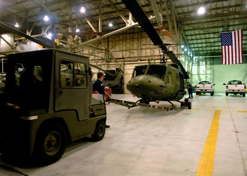 FAIRCHILD AIR FORCE BASE, Wash. - Civilian Department of Defense maintenance contractors with the 36th Rescue Flight tow a UH-1N “Huey” helicopter back into the hangar for post-flight inspections. The helicopter had just finished a training mission for recovery operations in conjunction with a 92nd Air Refueling Wing’s exercise recently. (U.S. Air Force photo/Airman 1st Class Joshua K. Chapman)