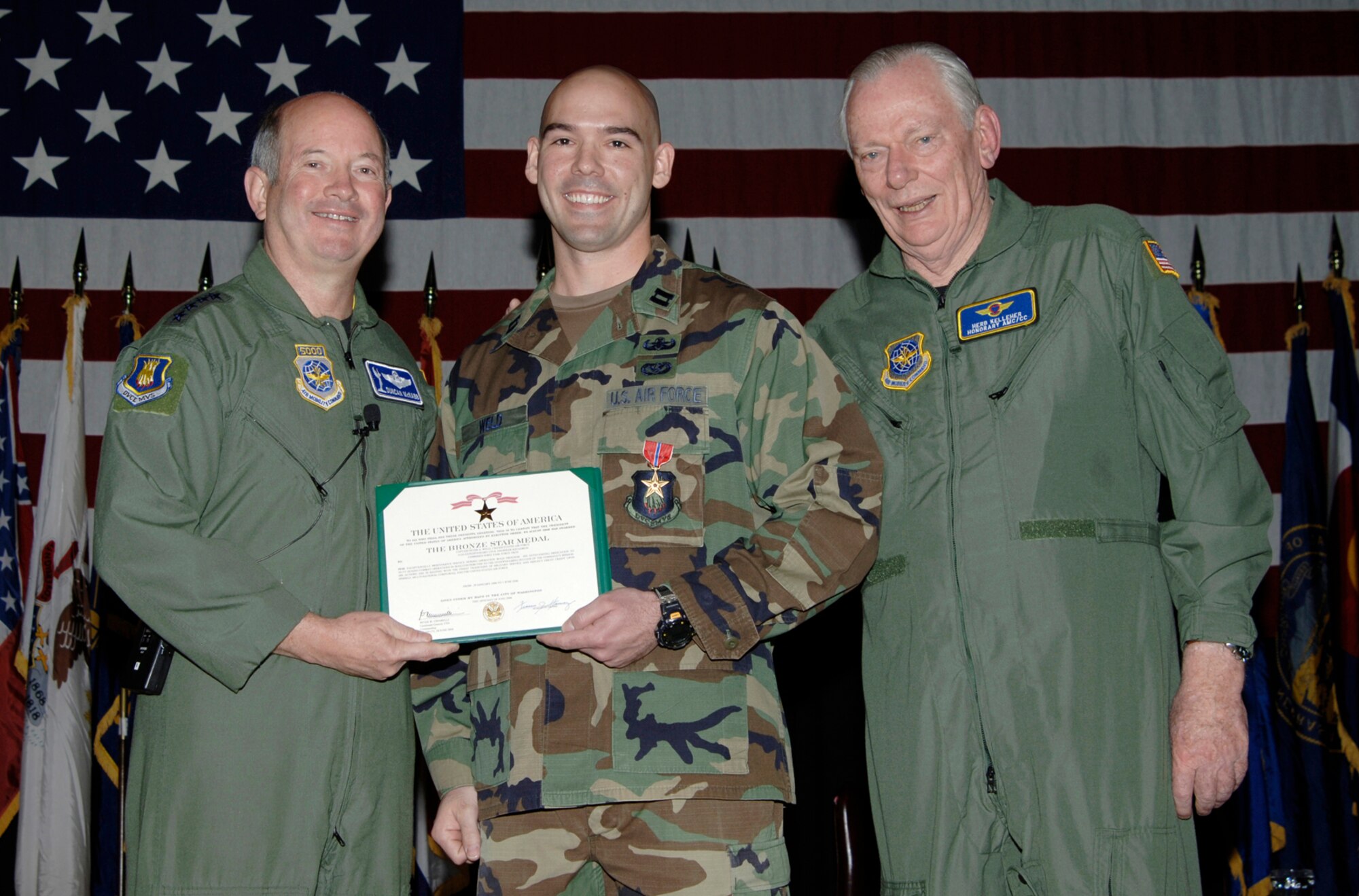During a visit to McConnell Air Force Base, Gen. Duncan McNabb, left, Air Mobility Commander, Scott Air Force Base, Ill., and Herb Kelleher, right, a founder and executive chairman of Southwest Airlines and AMC honorary commander, award Capt. Peter Weld, 22nd Civil Engineer Explosive Ordinance Disposal Flight, a Bronze Star April 5 at the Dole Center. Captain Weld received the bronze star for displaying exceptionally meritorious conduct and providing outstanding service to the United States while serving as commander of the 332nd explosive ordnance disposal flight, Logistic Support Area Anaconda, Iraq, from Jan. 29 to June 1, 2006. (Air Force photo by Senior Airman Jamie Train 22nd Communications Squadron)