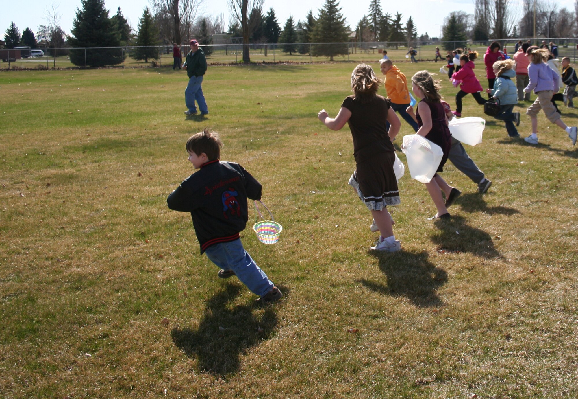 FAIRCHILD AIR FORCE BASE, Wash. -- Children, ages six to eight take off in a flash to start gathering Easter eggs that were spread across the field next to the tennis courts here April 1. The Easter egg hunt was just one of the activities scheduled for the children, the others included games, face painting, raffle drawings for prizes and a fire truck inflatable bounce toy from the base fire department. The event was attended by more than 200 people. (U.S. Air Force photo/Corrine Brown)