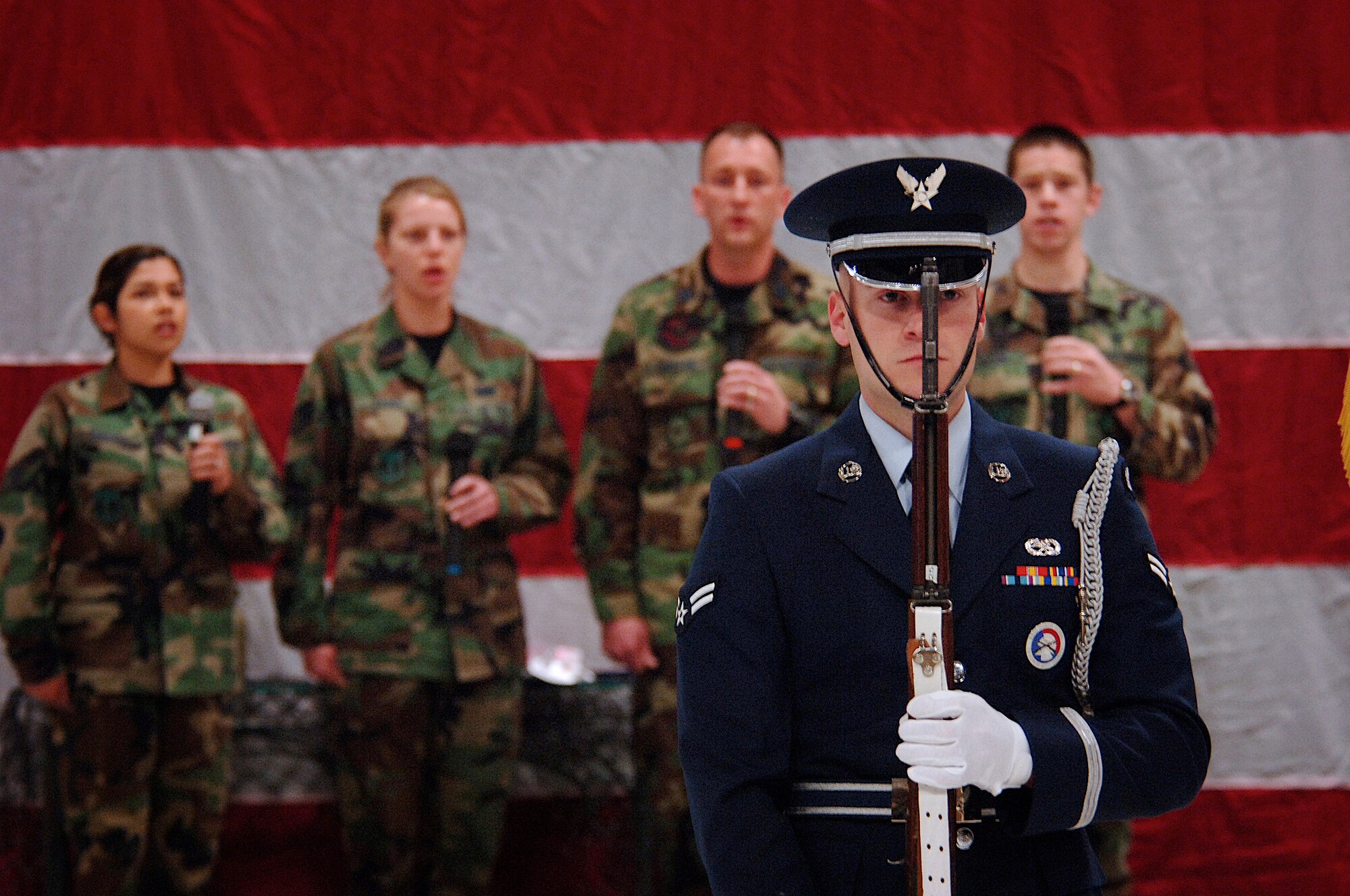 A Hill Honor Guard member presents arms during Hill Air Force Base’s National Prayer Breakfast held here March 29, while a small group of singers from the 75th Medical Group called the “Melodic Medics” sing the National Anthem. Photo by Efrain Gonzalez