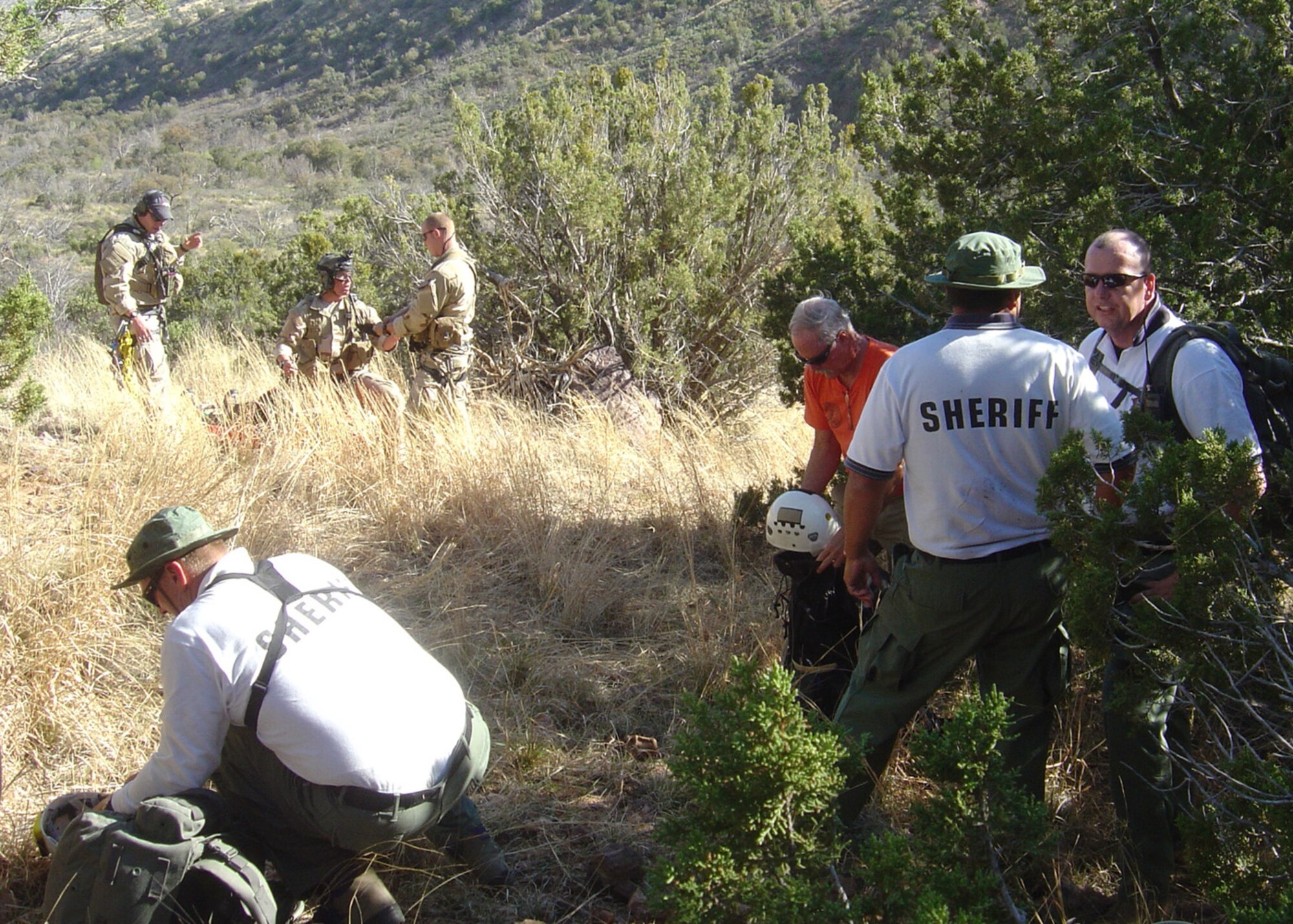 Members of the Pima County Sheriff Search and Rescue Team, Southern Arizona Rescue Association and 48th Rescue Squadron pararescuemen coordinate the evacuation of simulated injured and lost hikers during a local civil search and rescue exercise April 2 at Coronado National Forest, Ariz. (Air Force Photo by Tech. Sgt. Chad Watts)