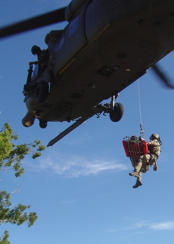 A 48th Rescue Squadron pararescuman and an injured hiker are hoisted into a hovering HH-60 Pave Hawk during an exercise to strengthen relations between Davis-Monthan and local civilian rescue agencies April 1.  The hiker was air lifted to University Medical Center in Tucson, Ariz., to complete the exercise. (Air Force Photo by Tech. Sgt. Chad Watts)