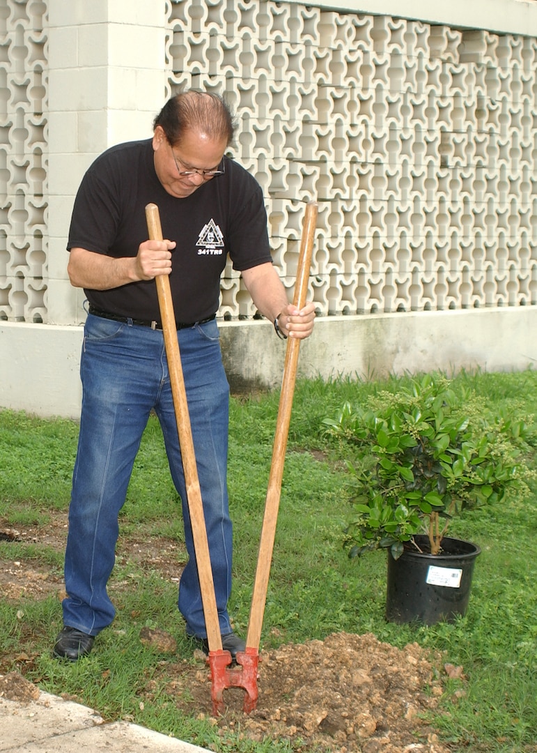 Morris Monita, a supply technician for the 341st Training Squadron, engages in some serious manual labor March 30 as part of the annual Team Lackland Beautification Day. Word is the soil around the squadron's building is hard clay and filled with rocks. (USAF photo by Sid Luna)                               