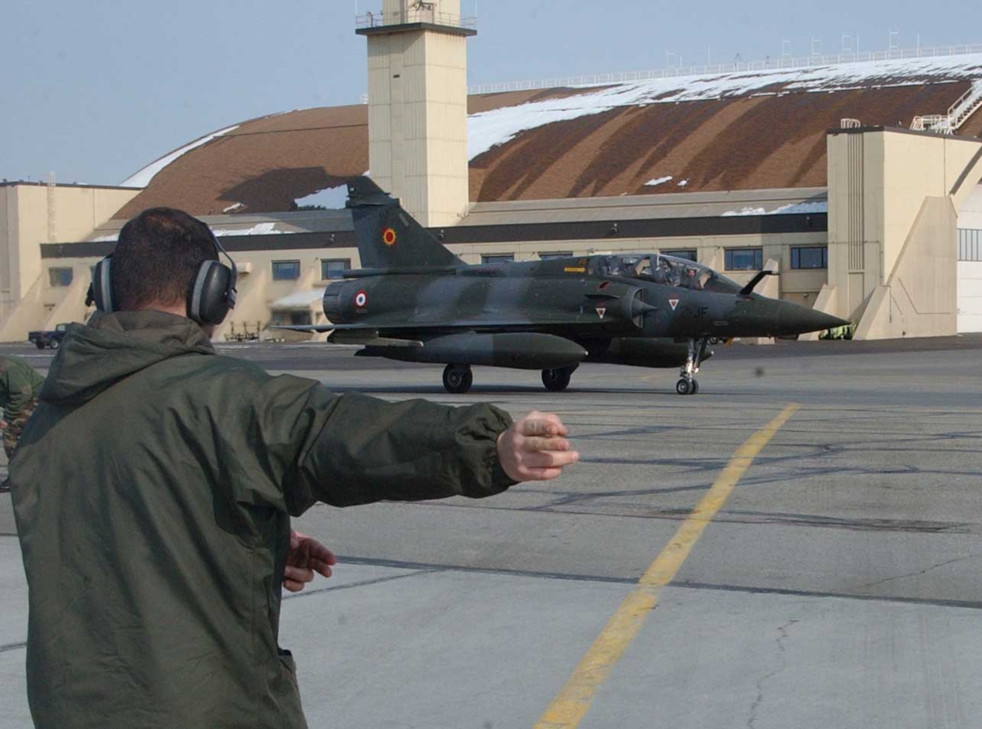 EIELSON AIR FORCE BASE, ALASKA --A French air force crew chief marshals a French Mirage 2000 jet on the flightline April 3. More than 1,300 air force personnel from the U.S., France and Australia are arriving in Alaska this week to take part in Red Flag-Alaska, a series of training exercises that include war games with allies and mock enemies. (U.S. Air Force photo by Senior Airman Justin Weaver).
                     