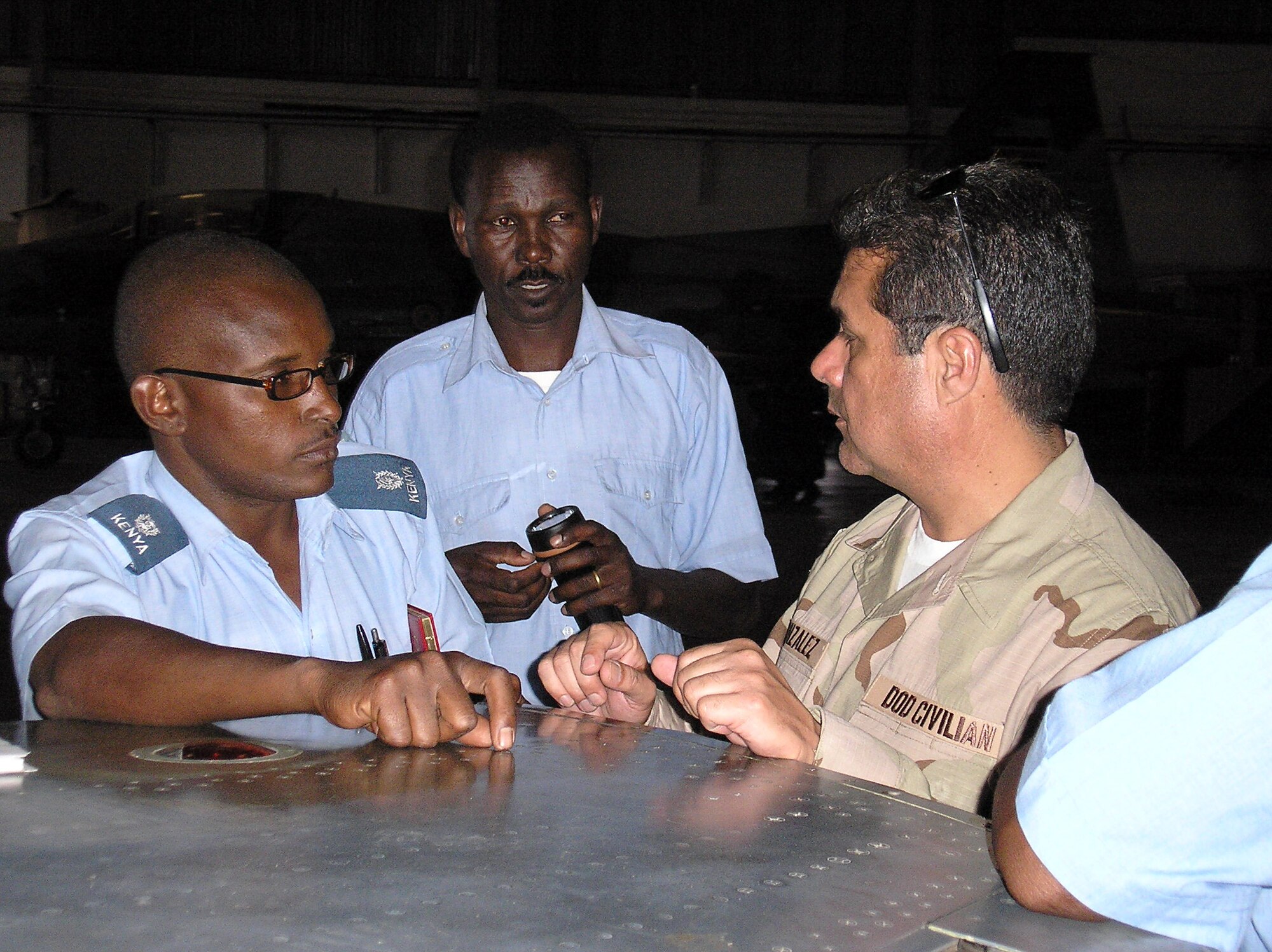 Mr. Mateo Gonzales (right) discusses maintenance inspections with members of the Kenyan air force at Laikipia Air Base in Kenya.  Mr. Gonzales is an F-5 fighter aircraft maintenance trainer at the Inter-American Air Forces Academy at Lackland Air Force Base, Texas.  He was part of an eight-man Air Force team visiting the East African nation to March 21 to 28 to improve aircraft maintenance processes.  (U.S. Air Force photo)