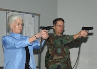 Nationally syndicated columnist Heloise prepares to fire during a tour March 29, 2007, at the 343rd Training Squadron at Lackland Air Force Base, Texas. She and Brig. Gen. Darrell Jones, a forrmer 37th Training Wing commander, tested their skill on a Firearms Training Simulator that uses computer generated imagery to create virtual training scenarios. General Jones escorted Heloise around Lackland following her speaking engagement at the Joint Services Luncheon.  (USAF photo by Alan Boedeker)                                