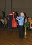 Heloise shows guests at the Joint Services Luncheon March 29 her mother's volunteer nurse's cape worn in the 1950s. Heloise, whose real name is Ponce Cruse, took over her mother's household hints column after her death in 1977. The original Heloise started the column while the family was stationed at Hickam AFB, Hawaii. The luncheon, hosted by the Lackland Officers' Spouses' Club, included the OSCs from Randolph AFB and Fort Sam Houston. (USAF photo by Alan Bodeker)
