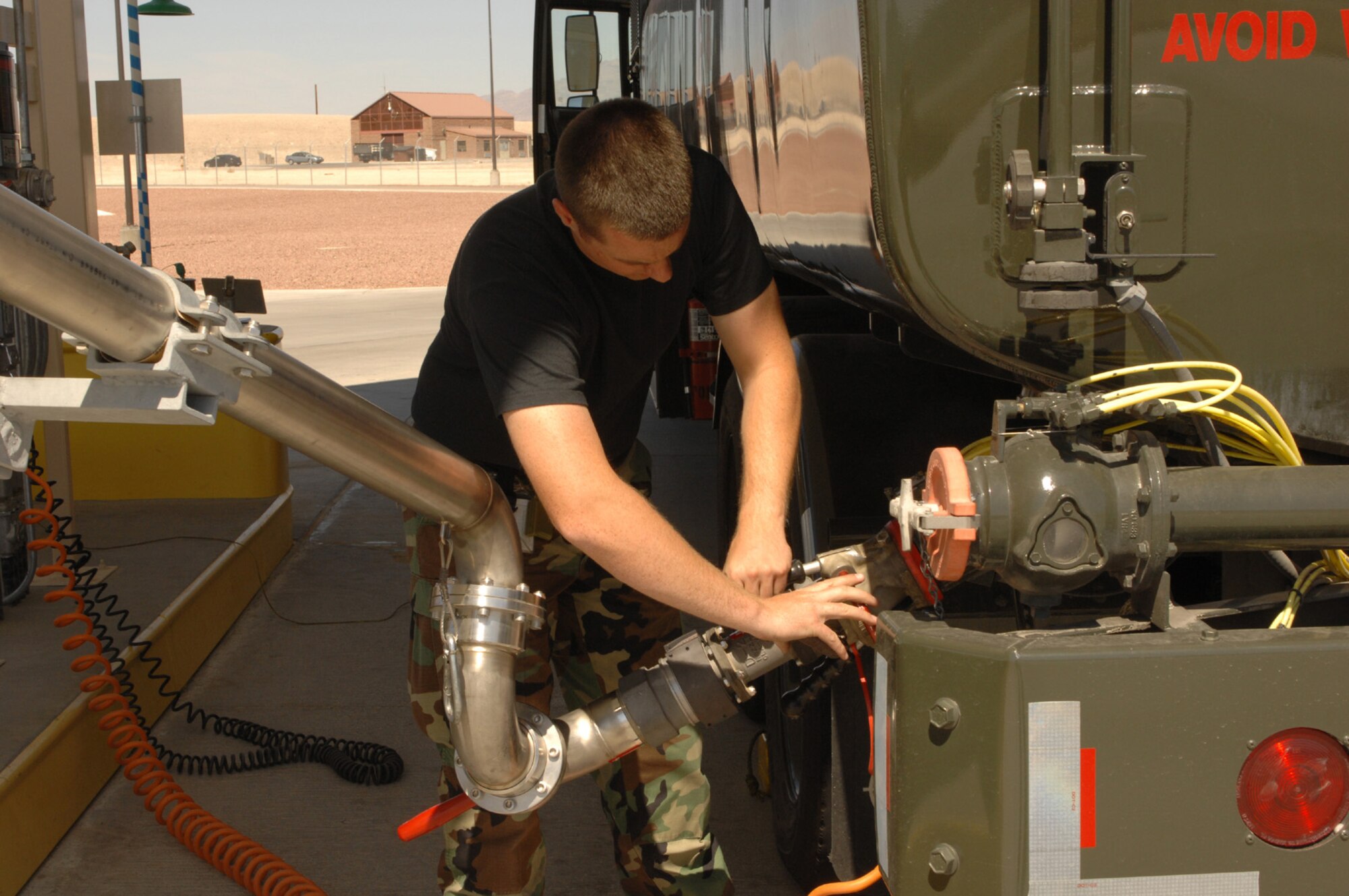 Airman 1st Class Eddie Downing 99th Logistics Readiness Squadron attaches a panagraph arm to the fuels truck to refuel a truck with JP-8 fuel. (U.S. Air Force Photo/Senior Airman Jason Huddleston)