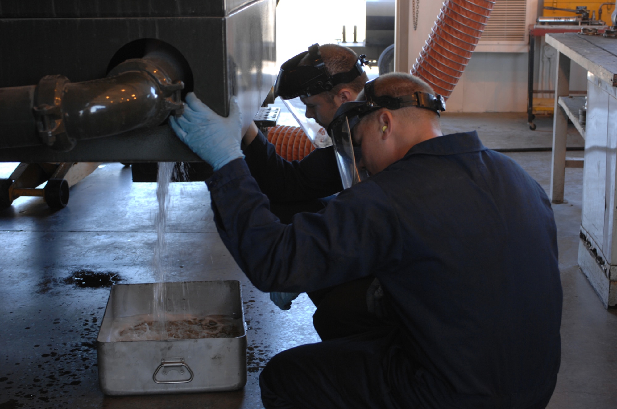 Senior Airman Daniel Young and Staff Sgt. Jefferson Perkins drain JP-8 fuel as part of the inspection for preparation to be shipped out (U.S. Air Force Photo/Senior Airman Jason Huddleston)