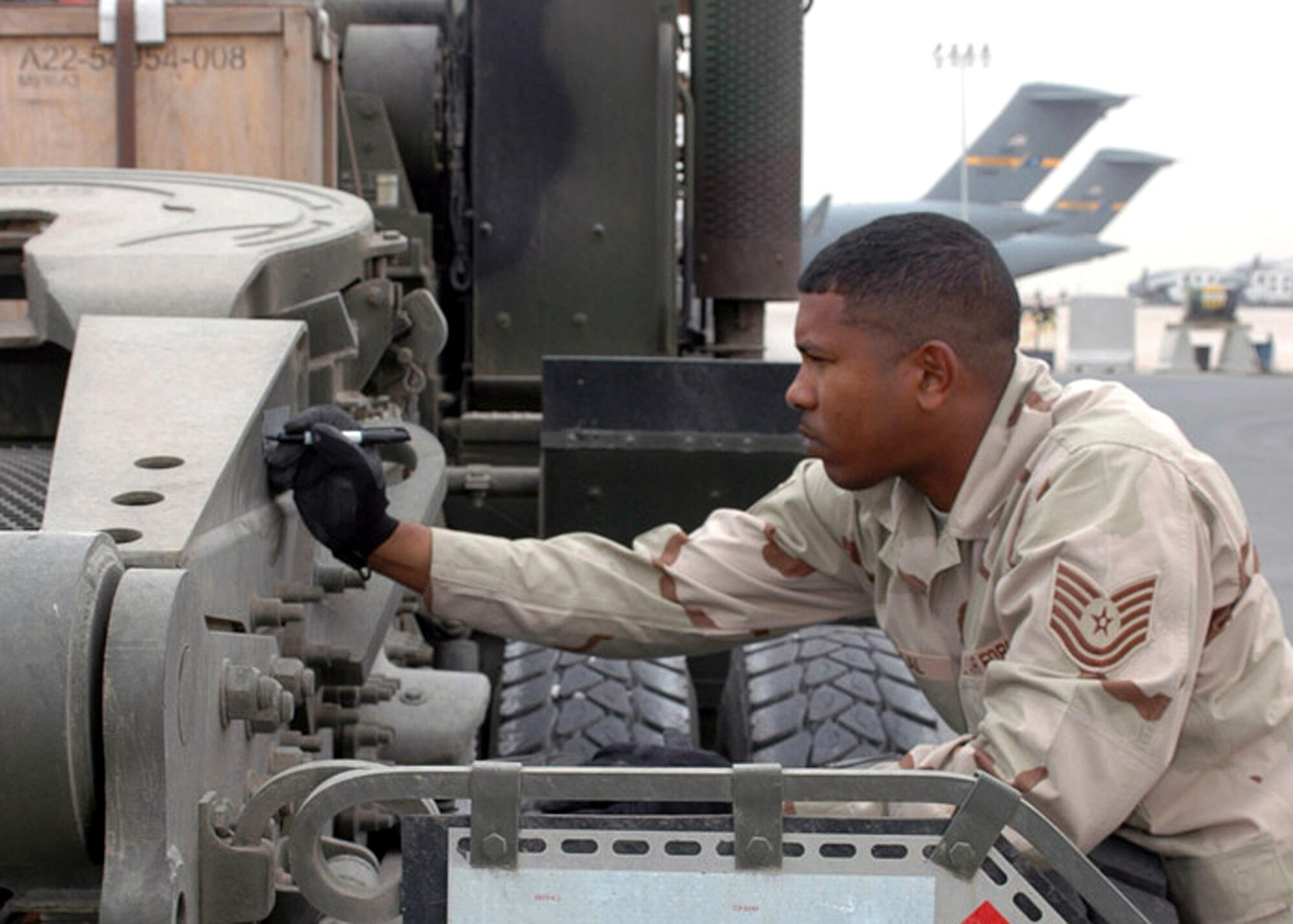 Tech. Sgt. Garth Chablal prepares a large truck for shipment to Afghanistan on a C-17 Globemaster III based out of the 379th Air Expeditionary Wing.  Airmen in 379th AEW have increased their activities to support surge operations in Iraq and Afghanistan. Sergeant Chablal is an air freight supervisor with the 8th Expeditionary Air Mobility Squadron.  (U.S. Air Force photo/Senior Airman Erik Hofmeyer)