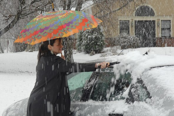 Mary Keane, Hanscom Primary School second grade teacher, brushes the slush off of her car Wednesday during an April snow shower. (US Air Force Photo by Linda LaBonte Britt)
