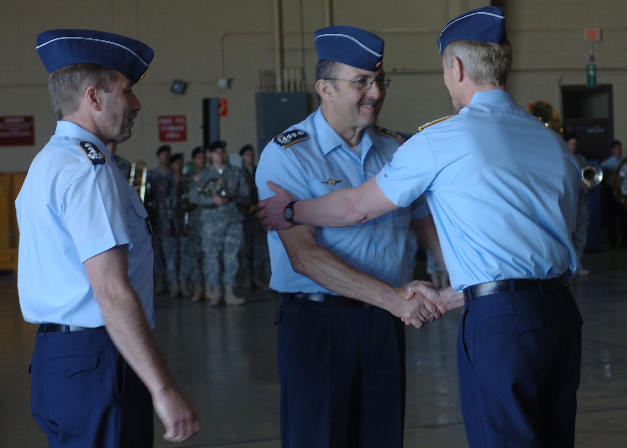 Col. Heinz Joachim Hecht, German air force U.S./Canada commander, looks on as Col. Peter Klement, German air force commander, greets former German Air Force Commander Manfred Molitor after the change of command ceremony.